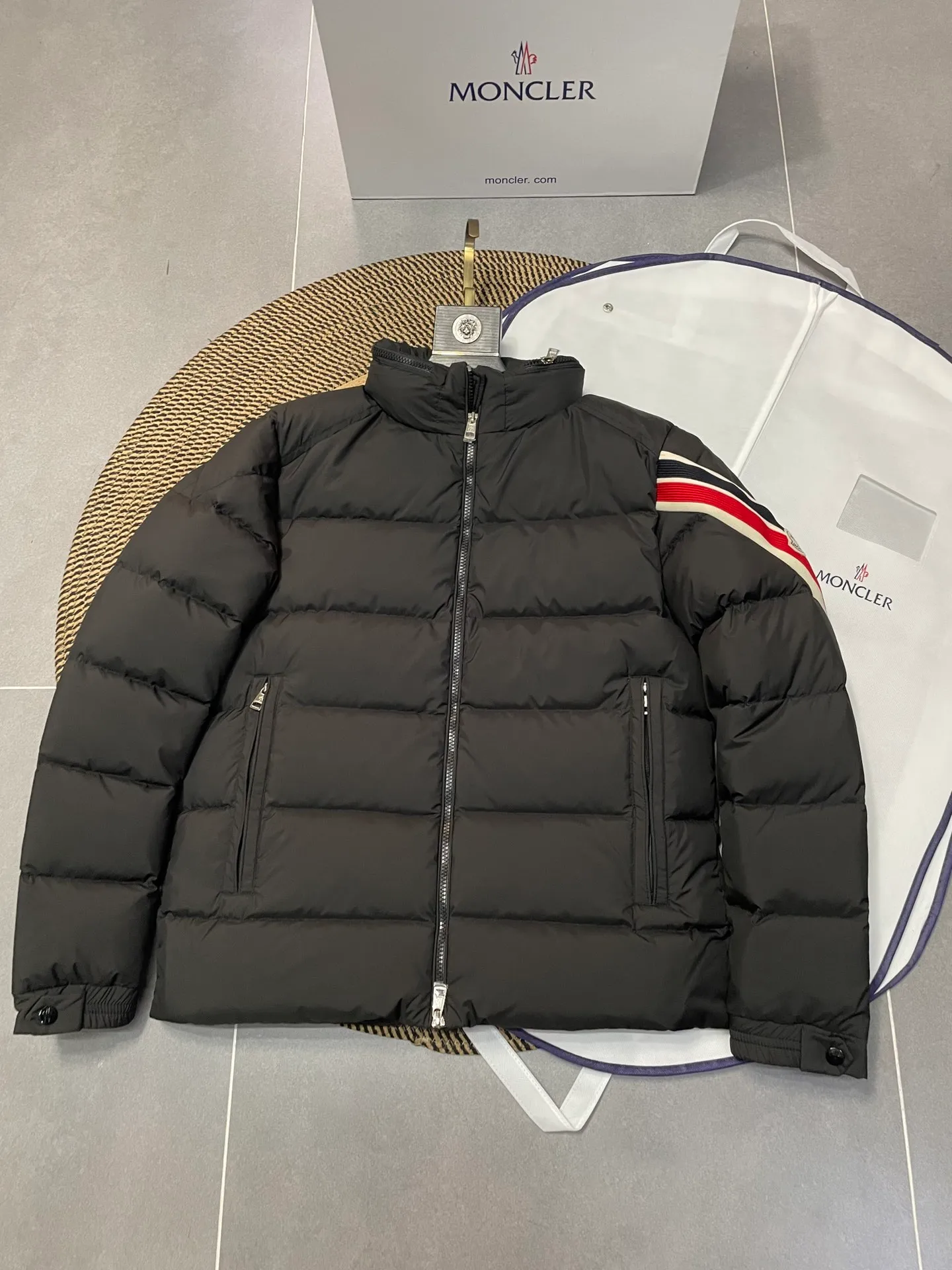 P840 🆕❤️2️⃣0️⃣2️⃣4️⃣🆕Premium down⬆️Moncler Solayan men's three-color trim short down jacket. Premium goose down filling. The finest, lightest and neatest fabric. Solayan men's short down jacket is decorated with seasonal iconic stripe details, blending sportsmanship and timeless style.  The Solayan down jacket is made of micro chic fabric and has a tough square shape design, highlighting Moncler's sporty spirit. This cropped down jacket features tricolor stripes on the sleeves, a seasonal take on the brand's signature. Comes with a practical pull-out hood. Details •Made from micro chic nylon fabric •Micro chic nylon lining •Down filled •Pull-out hood •Zip closure •Zip pockets •Adjustable cuffs •Elastic drawstring hem •Tri-color trim on sleeves Size: 1-5 Color: White Dark Brown Black