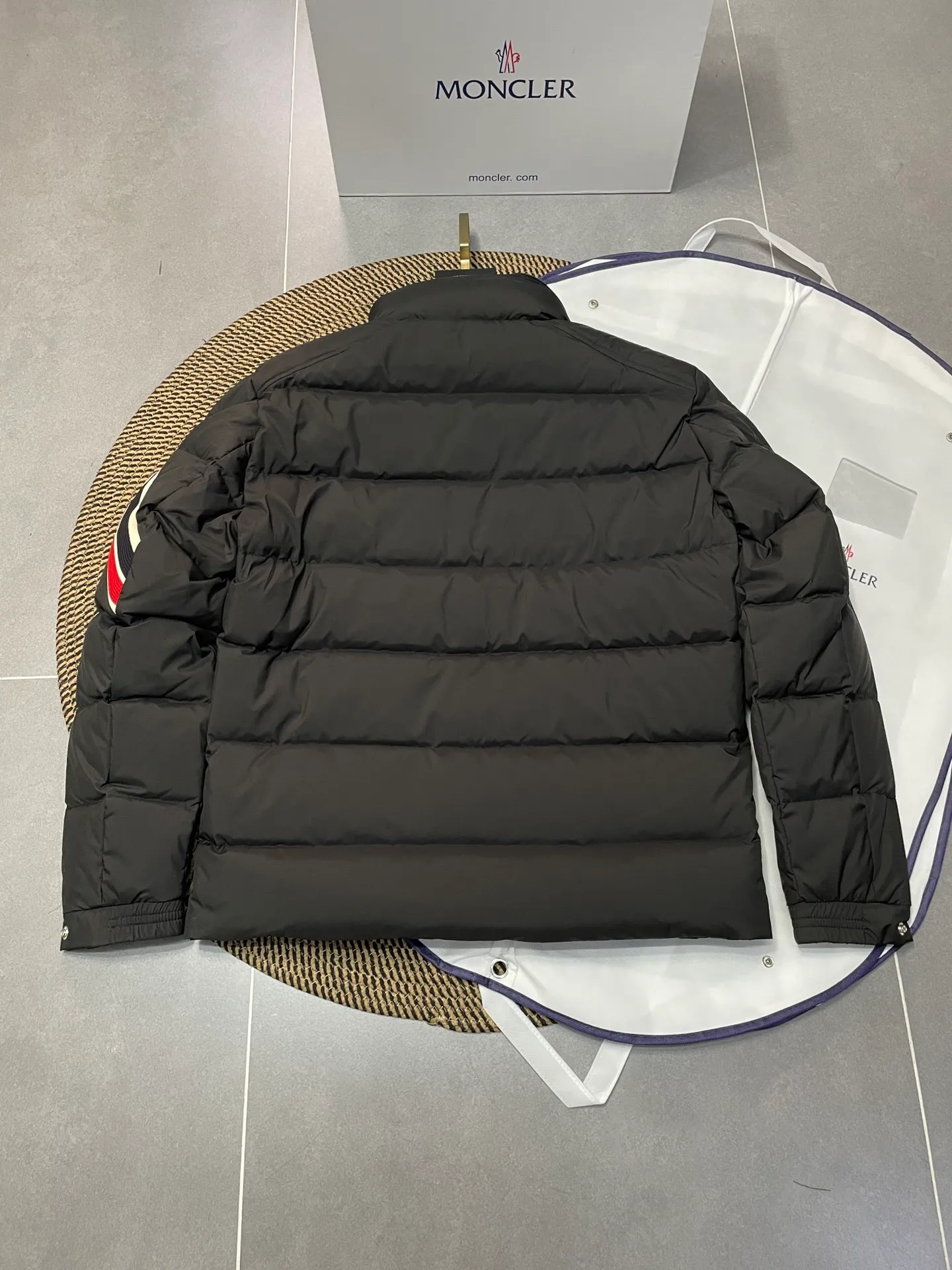P840 🆕❤️2️⃣0️⃣2️⃣4️⃣🆕Premium down⬆️Moncler Solayan men's three-color trim short down jacket. Premium goose down filling. The finest, lightest and neatest fabric. Solayan men's short down jacket is decorated with seasonal iconic stripe details, blending sportsmanship and timeless style.  The Solayan down jacket is made of micro chic fabric and has a tough square shape design, highlighting Moncler's sporty spirit. This cropped down jacket features tricolor stripes on the sleeves, a seasonal take on the brand's signature. Comes with a practical pull-out hood. Details •Made from micro chic nylon fabric •Micro chic nylon lining •Down filled •Pull-out hood •Zip closure •Zip pockets •Adjustable cuffs •Elastic drawstring hem •Tri-color trim on sleeves Size: 1-5 Color: White Dark Brown Black