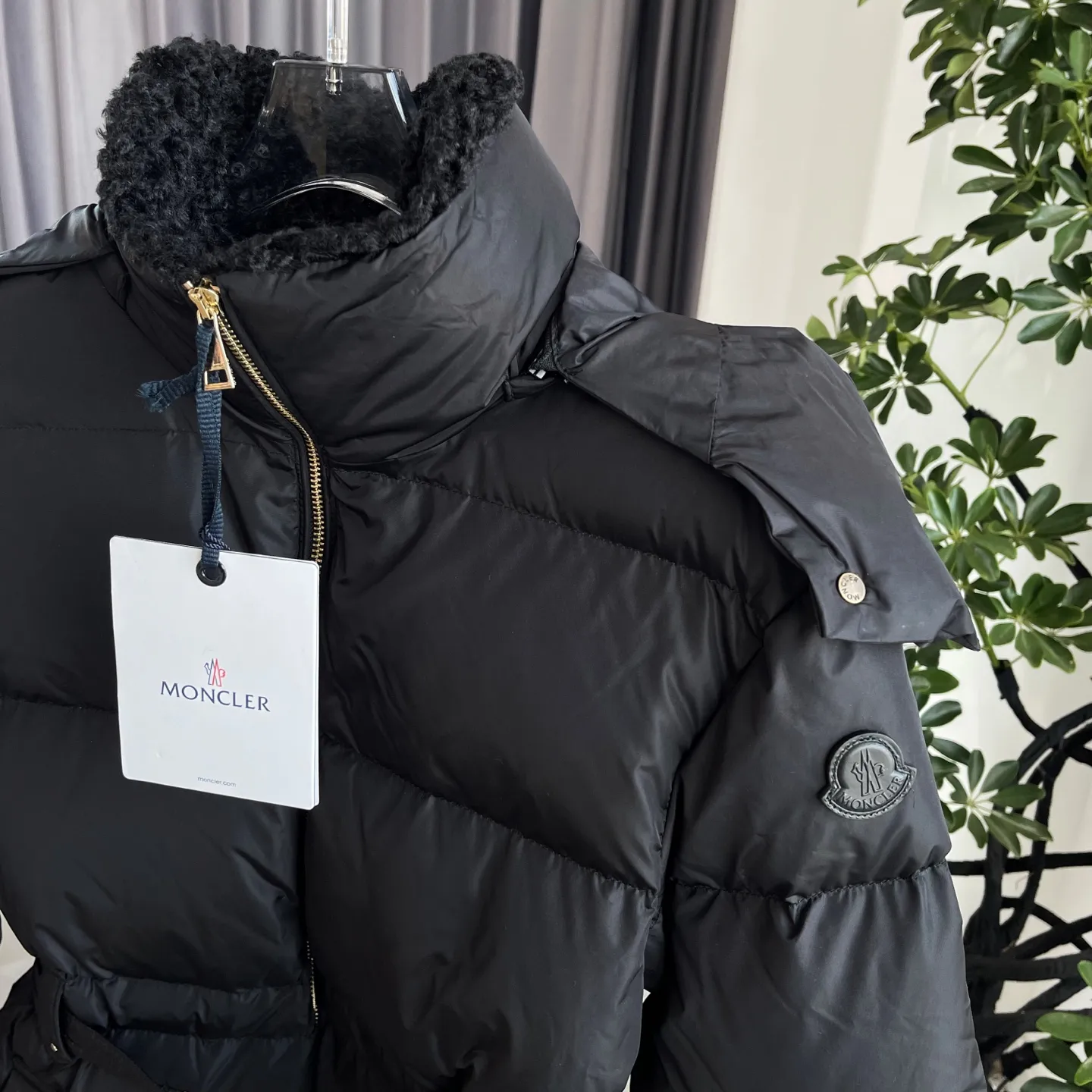 P1120 Moncler Briant Women's Hooded Long Waisted Down Jacket Jacket The Briant down jacket is designed to be both practical and comfortable to meet daily needs. Functional nylon fabric combined with a removable hood makes it easy to adapt to changing weather. This warm piece's wrap silhouette can be transformed from practical to sophisticated by adding a feminine touch with a detachable belt. The teddy velvet style collar design highlights the gentle style. Color: Black Size: 0/1/2/3