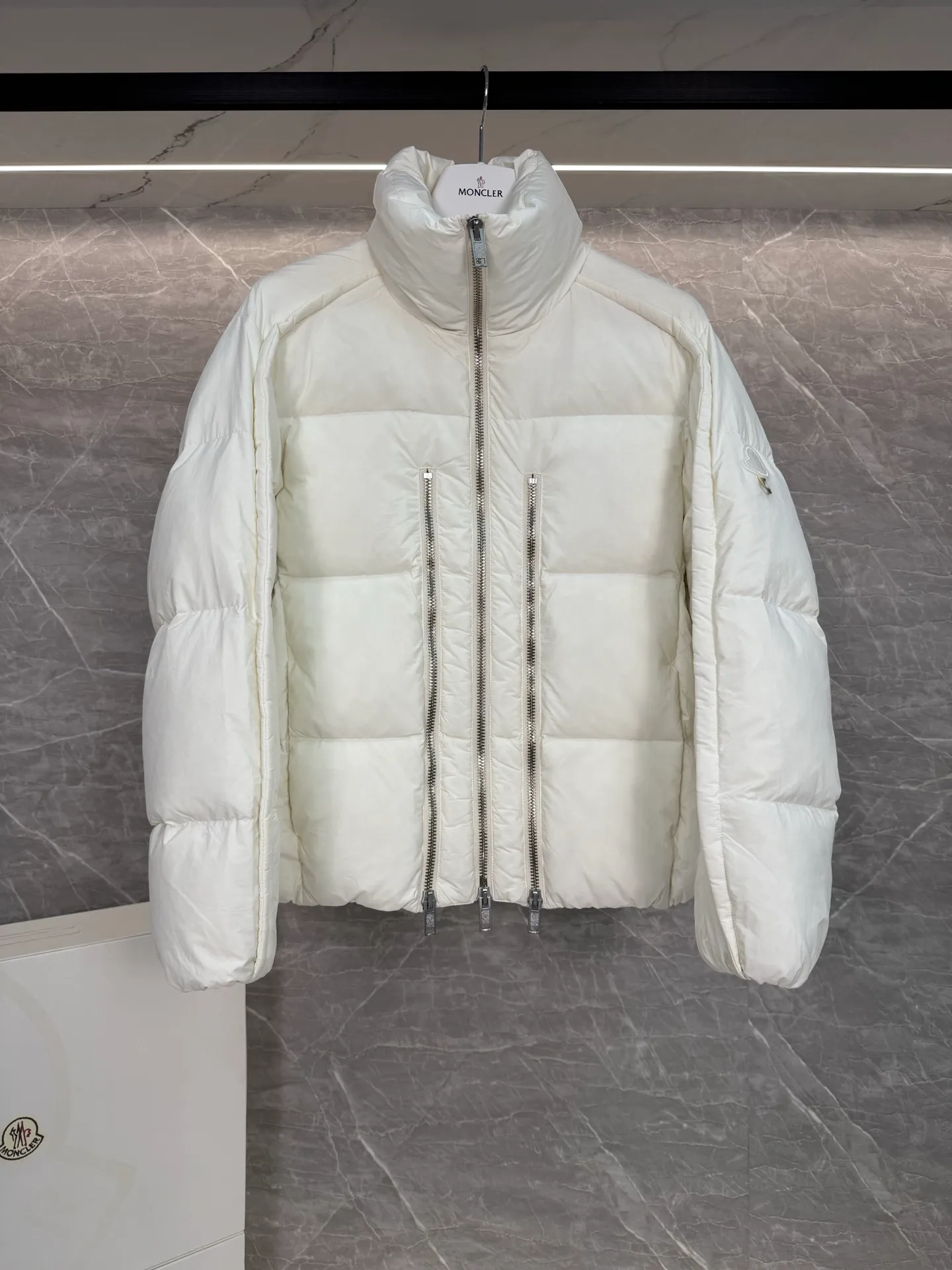 P1140 ⬆️ MONCLER GENIUS (Sky City Show Style) Moncler x Willow Smith YAEL Short Women's Down Jacket Jayel short down jacket is embellished with eye-catching metal accessories, highlighting the punk aesthetic of the Moncler x Willow Smith women's series.  The Moncler x Willow Smith Jayel down jacket features an extra zipper on the front, reinterpreting a signature punk detail. These functional zippers can be opened or closed and are reminiscent of artist-inspired vintage details. Made from nylon fabric that combines Moncler's heritage with Willow Smith's aesthetic, the metal ring on the logo patch is inspired by the artist's nose ring. Moncler Genius is a warm piece with a short and wide design that can be easily matched with the same color items in the series. Details Made of lightweight nylon Longue saison lining Filled with down Zip closure Snap pockets Adjustable cuffs and hem Embroidered logo patch with hoop Size: 0-3 White Black (Fairy Style)