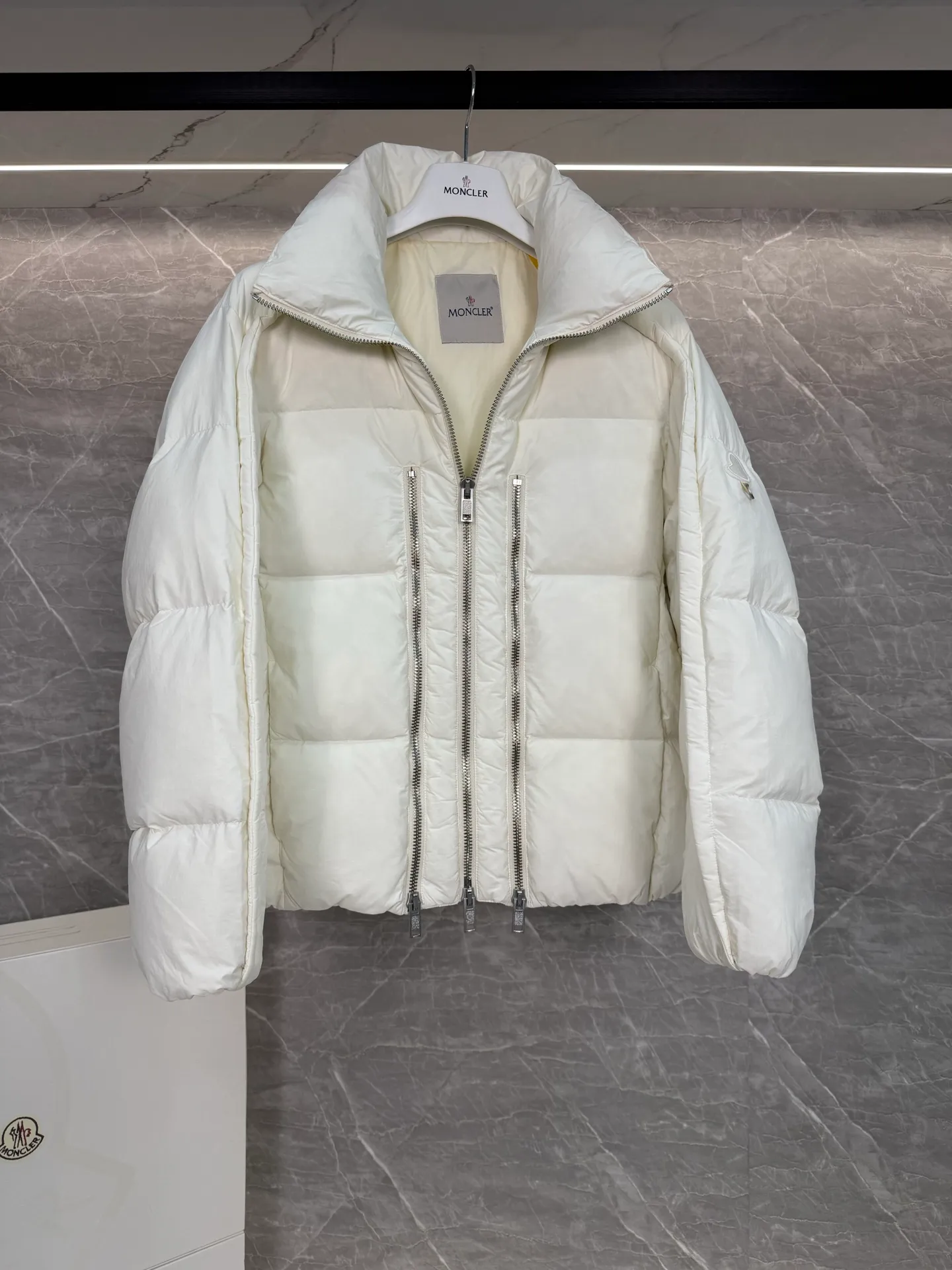 P1140 ⬆️ MONCLER GENIUS (Sky City Show Style) Moncler x Willow Smith YAEL Short Women's Down Jacket Jayel short down jacket is embellished with eye-catching metal accessories, highlighting the punk aesthetic of the Moncler x Willow Smith women's series.  The Moncler x Willow Smith Jayel down jacket features an extra zipper on the front, reinterpreting a signature punk detail. These functional zippers can be opened or closed and are reminiscent of artist-inspired vintage details. Made from nylon fabric that combines Moncler's heritage with Willow Smith's aesthetic, the metal ring on the logo patch is inspired by the artist's nose ring. Moncler Genius is a warm piece with a short and wide design that can be easily matched with the same color items in the series. Details Made of lightweight nylon Longue saison lining Filled with down Zip closure Snap pockets Adjustable cuffs and hem Embroidered logo patch with hoop Size: 0-3 White Black (Fairy Style)