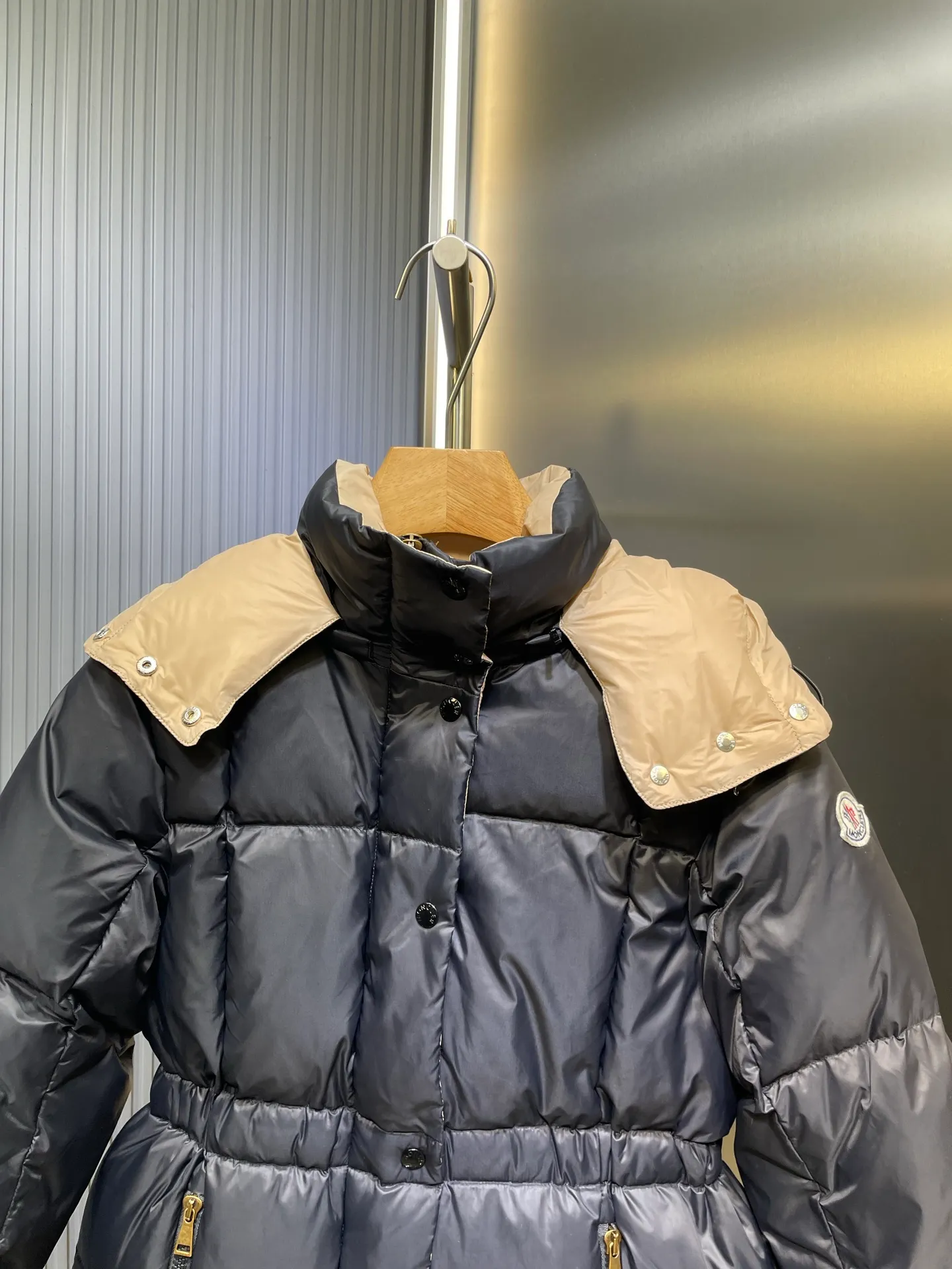 P910 MONCLER 25FW new autumn and winter product. Waisted black gold Agneux women's square quilted hooded short down jacket. The Agneux down jacket combines protective fabrics and exquisite textures. Short fit in functional nylon with a glossy satin finish. Paired with a nipped-in waist design, it outlines a feminine silhouette. Made of nylon Longue saison lining Filled with down Detachable and adjustable hood Zip and snap fastening Zippered pockets Elastic waist Black Apricot Sizes S M L
