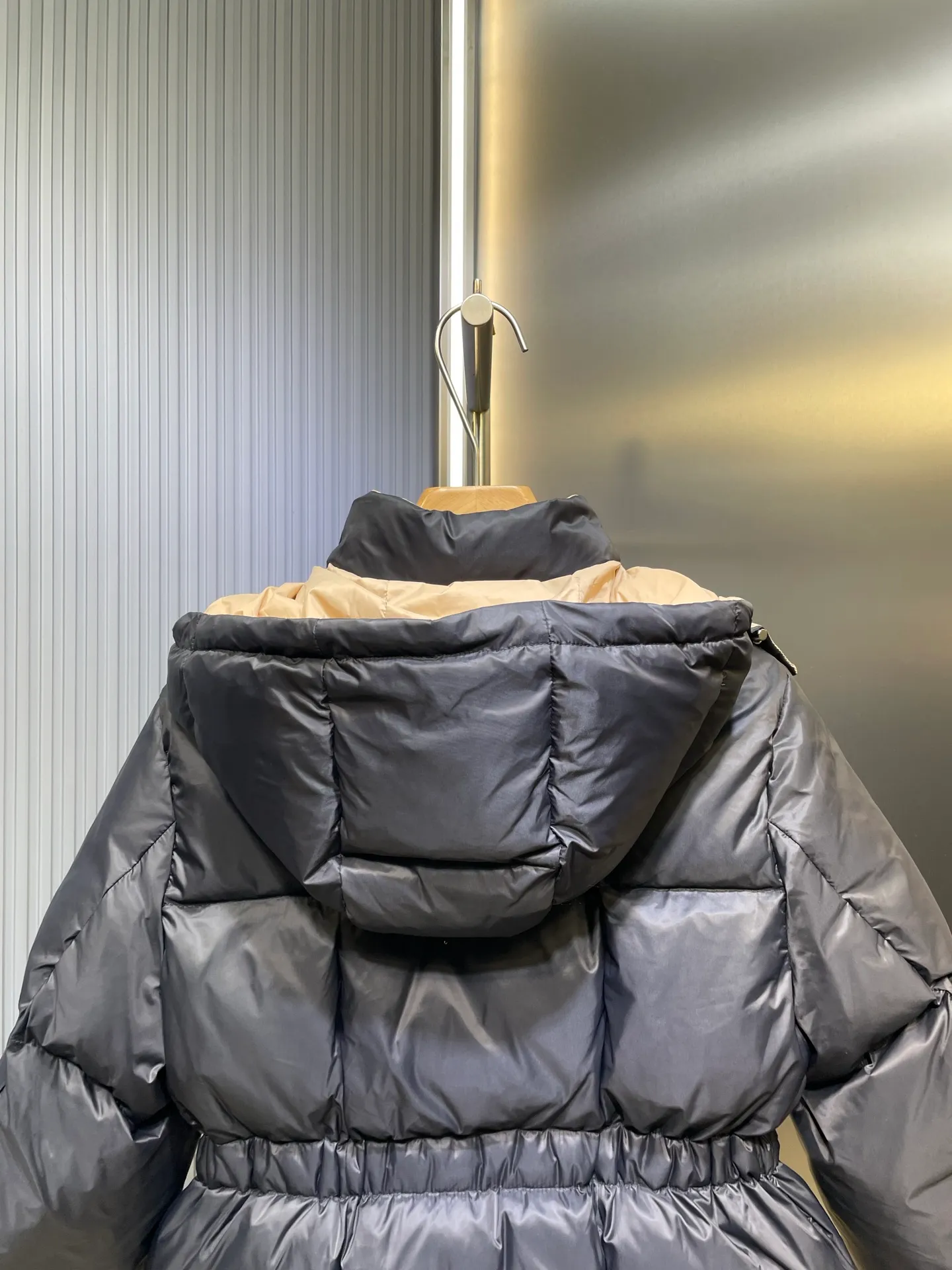 P910 MONCLER 25FW new autumn and winter product. Waisted black gold Agneux women's square quilted hooded short down jacket. The Agneux down jacket combines protective fabrics and exquisite textures. Short fit in functional nylon with a glossy satin finish. Paired with a nipped-in waist design, it outlines a feminine silhouette. Made of nylon Longue saison lining Filled with down Detachable and adjustable hood Zip and snap fastening Zippered pockets Elastic waist Black Apricot Sizes S M L