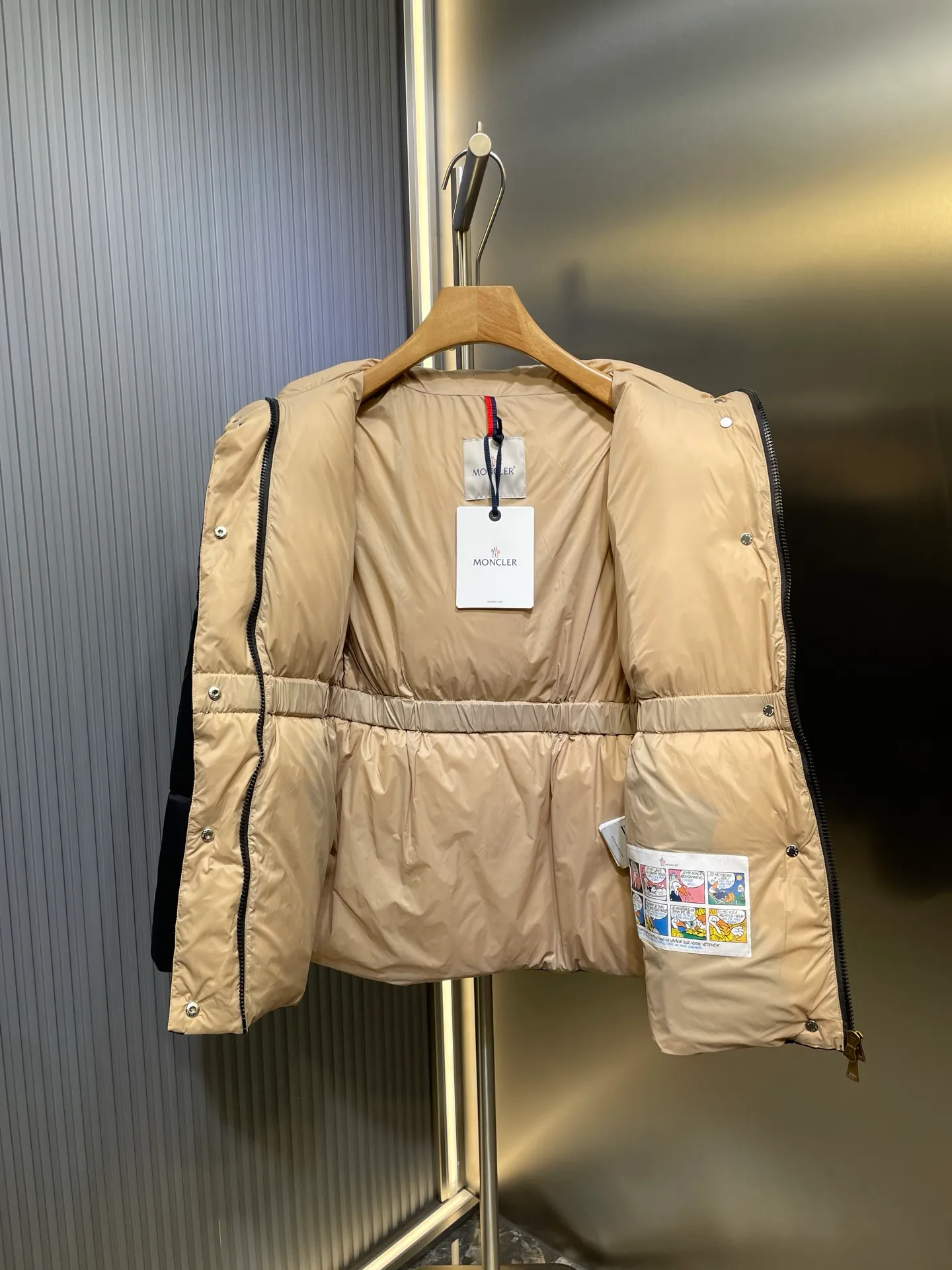 P910 MONCLER 25FW new autumn and winter product. Waisted black gold Agneux women's square quilted hooded short down jacket. The Agneux down jacket combines protective fabrics and exquisite textures. Short fit in functional nylon with a glossy satin finish. Paired with a nipped-in waist design, it outlines a feminine silhouette. Made of nylon Longue saison lining Filled with down Detachable and adjustable hood Zip and snap fastening Zippered pockets Elastic waist Black Apricot Sizes S M L