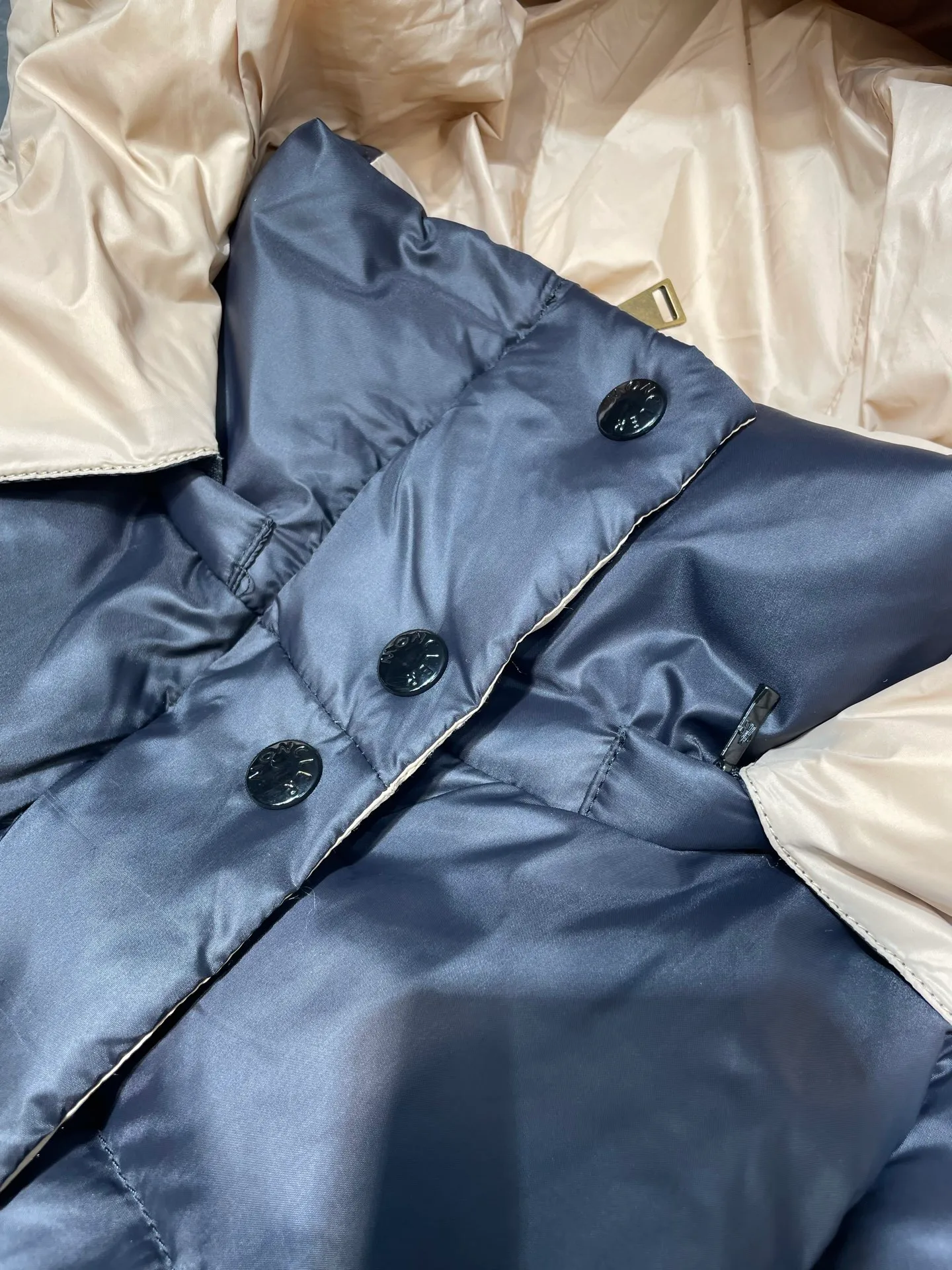 P910 MONCLER 25FW new autumn and winter product. Waisted black gold Agneux women's square quilted hooded short down jacket. The Agneux down jacket combines protective fabrics and exquisite textures. Short fit in functional nylon with a glossy satin finish. Paired with a nipped-in waist design, it outlines a feminine silhouette. Made of nylon Longue saison lining Filled with down Detachable and adjustable hood Zip and snap fastening Zippered pockets Elastic waist Black Apricot Sizes S M L
