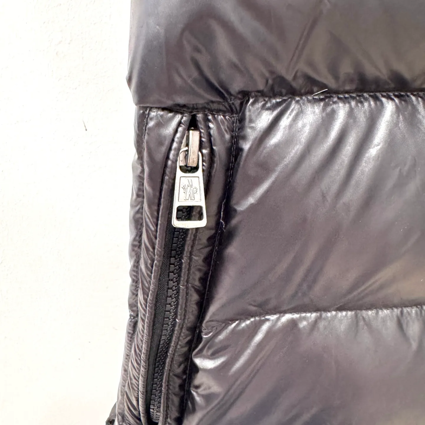 P560 Tibb men's down vest] Tibb men's down vest is a classic Moncler design item made of nylon laqué fabric.     The Tibb men's down vest is a classic Moncler item, inspired by the iconic archival silhouette of the 1980s. Made from lightweight nylon laqué functional fabric, it's perfect for changing seasons.  •Made of nylon laqué •Nylon laqué lining •Down filled •Snap-stud collar •Zip closure •Zip pockets •Fabric: 100% nylon; •Lining: 100% nylon; •Filling: goose down •Down content: 90%; except trim; •Size: 12345 Maximum wash temperature 30°C - Gentle wash; Do not bleach; Do not tumble dry; Ironing maximum temperature 110°C - without steam; Do not dry clean; Professional wet cleaning - Gentle wash; Lay flat to dry in shade; Wash separately; Recommend washing and ironing inside out