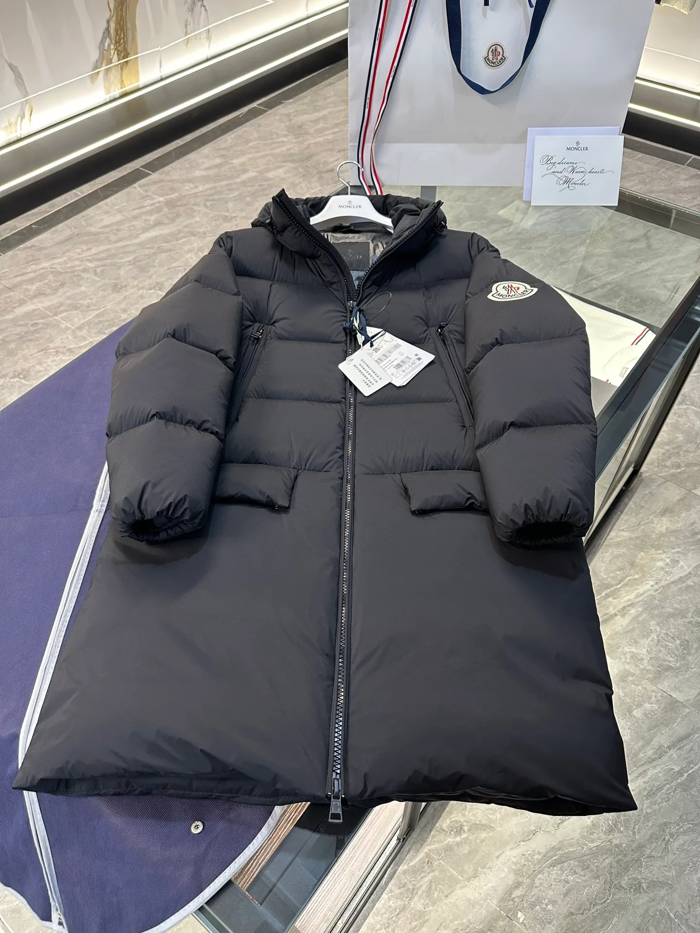P880 Moncler Bosona mid-length large felt badge down jacket. More details shot.