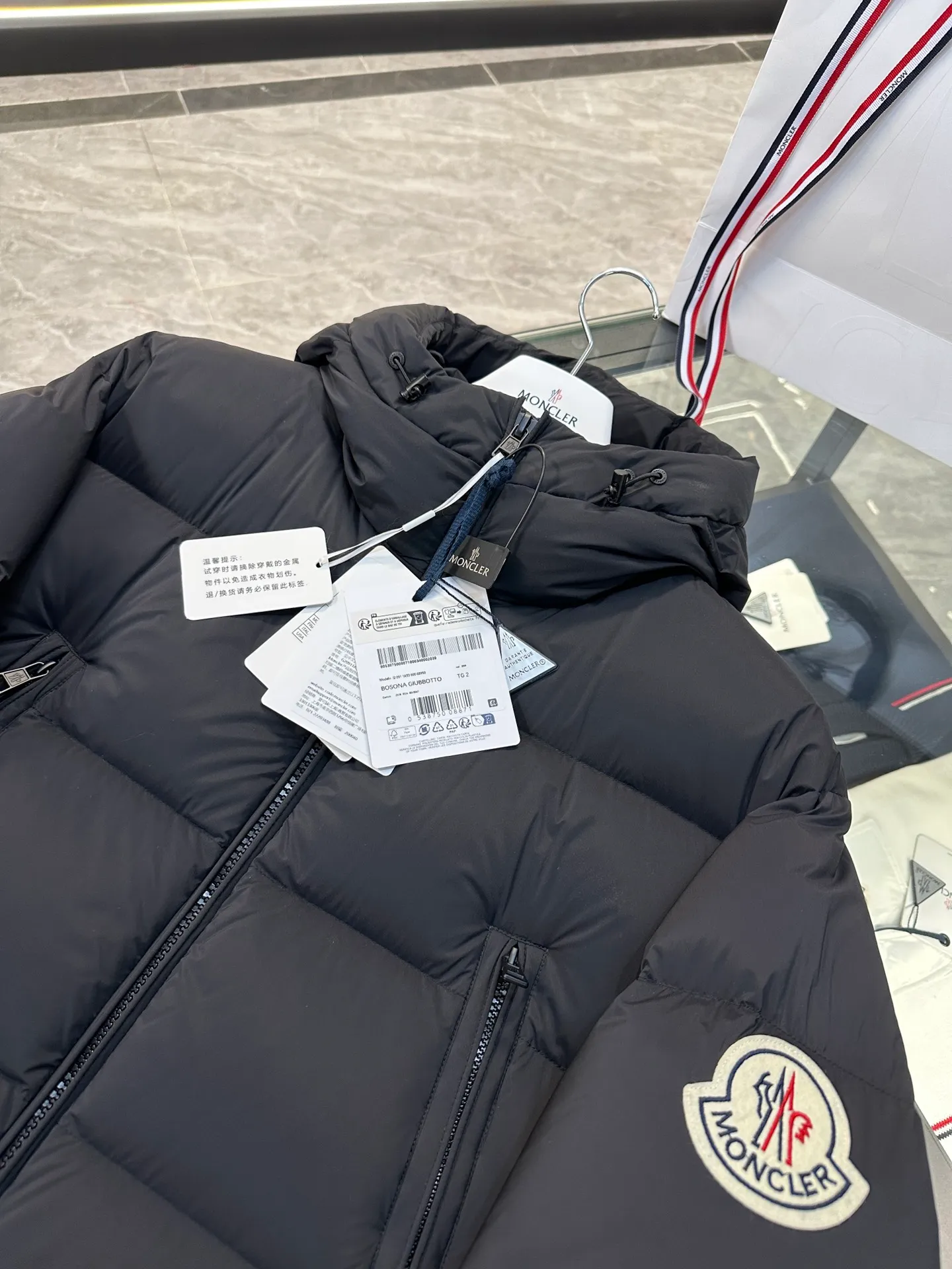 P880 Moncler Bosona mid-length large felt badge down jacket. More details shot.