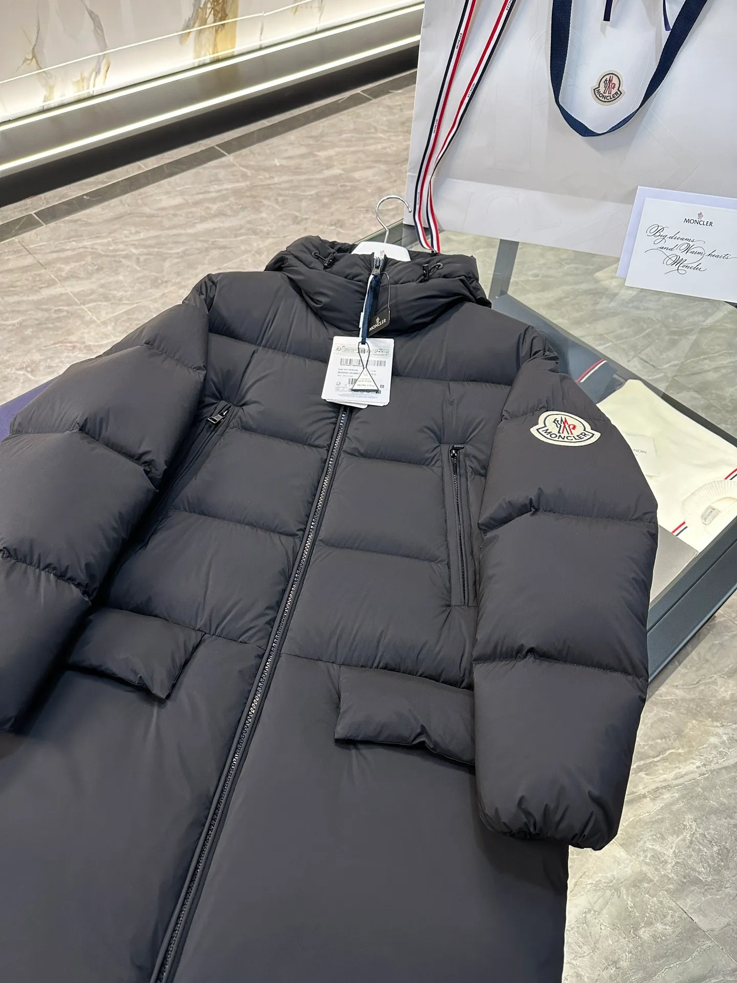 P880 Moncler Bosona mid-length large felt badge down jacket. More details shot.