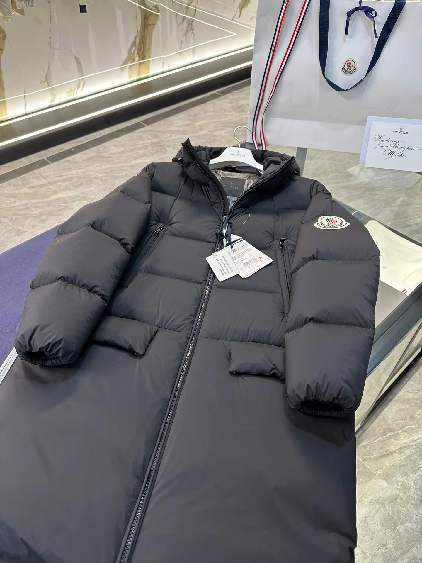 P880 Moncler Bosona mid-length large felt badge down jacket. More details shot.