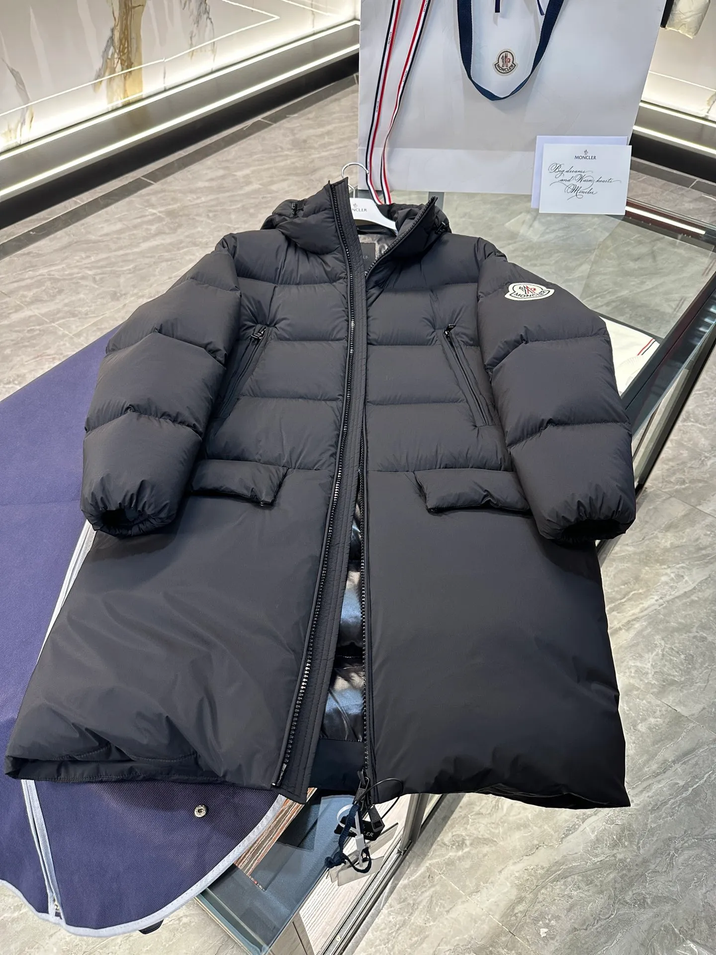 P880 Moncler Bosona mid-length large felt badge down jacket. More details shot.