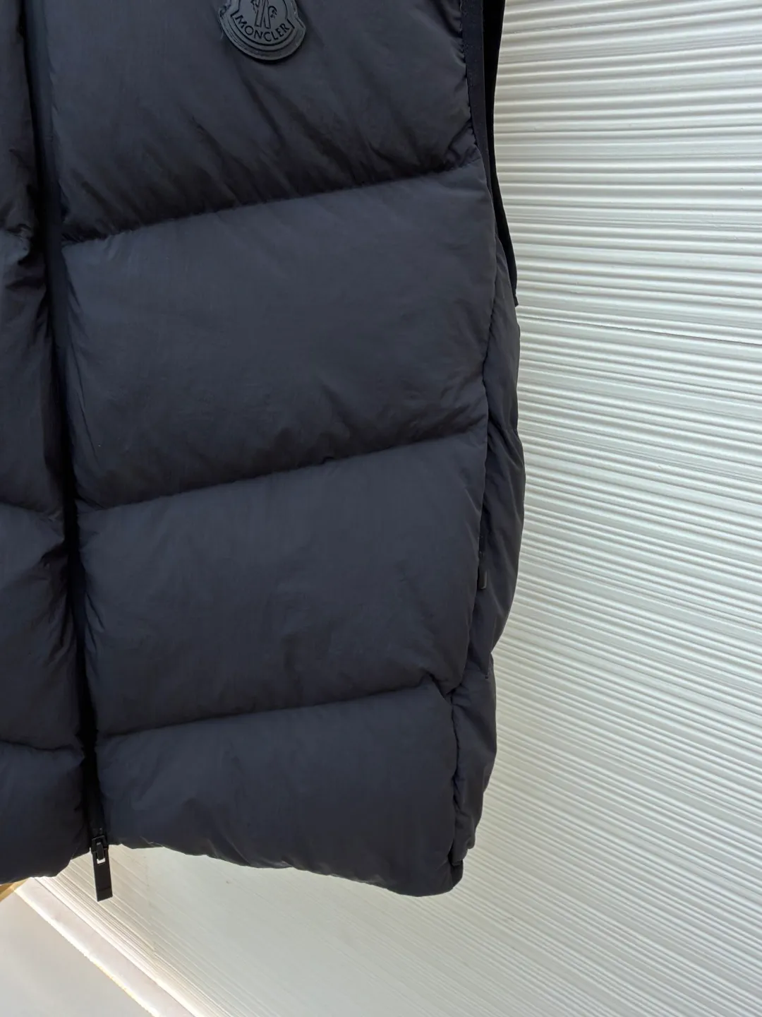 P670 MONCLER emblem hooded down vest ●Original version: purchased and developed by 6269 ●Item number: 1681645-C00 ●Fabric: white duck down fabric ●Technology: mechanical down filling ●Color: black ●Version: fitted version ●Weight: about 565 grams ●Size: 1-2-3-4 ●Description: The nylon fabric made of 100% nylon is woven into a tight and tough fabric through advanced textile technology. The strength of the frame is increased to effectively block the invasion of cold wind and lock the warm air generated by the down layer. After a tight weaving process and special treatment, it is waterproof and windproof. The surface forms a certain lotus leaf effect. It is also wrinkle-resistant and not easy to deform, making it easy for daily care. The quilting stitches are sewn in a diagonal direction at an angle of about 70 degrees, and the diagonal lines are arranged in parallel. The fabric and filling are planned into different functional areas, and the quilting stitches in each partition are relatively independent. This allows the finished product to produce a larger deformation space along the diagonal direction when stretched and pressed, making it less likely to tighten and break, and has rich visual effects, modern and advanced features. After the hood is removed, the stand-up collar displays an embossed logo of the same color, adding a unique visual experience and tactile details. Filled with 90% selected white duck down and weighing 170g, it ensures fluffiness, quick rebound, lightness and warmth. The overall wiring is straight and delicate, the fabric is comfortable and soft, and the color is consistent without color difference. It can be matched with the same style to create a fashionable look and control various occasions. Customized accessories, complete with three standards, same style for men and women!