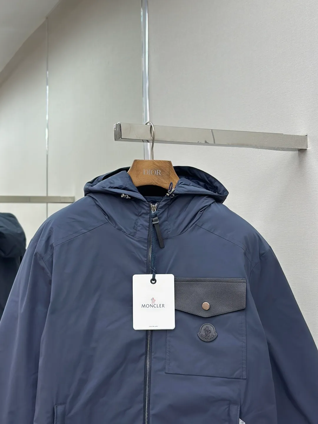 P890 MONCLER hooded jacket-style down jacket is made of 100% polyester fiber. After microfiberization treatment, the individual fibers become extremely fine, which greatly increases the fiber surface area, making the fabric soft and smooth, and the touch is close to natural fibers. The high-density textile method makes the structure tight, thus giving it a certain degree of wrinkle resistance, windproof warmth and wear resistance.  Lining selection: High-density lining fabric made of ultra-fine denier, 0.08mm thickness to avoid increasing the overall weight and making it smooth to wear. The high-density woven structure forms a wind resistance layer to protect the thermal efficiency of the thermal layer from loss. It can also withstand the expansion pressure of down and prevent deformation and damage after long-term use.  High-quality filling: 90 white duck down is selected, with a weight of 200g, ensuring excellent thermal insulation performance. After strict screening and treatment, the velvet is not easy to be drilled, ensuring durability. Details: The leather flap pocket on the chest is matched with a pebbled leather flap + matte metal buckle. It is low-key and exudes nobility. The hidden adjustment rope gives a sense of sophistication when you raise your hand. The "ID card" is directly embedded on the black satin inner patch pocket! Silver snaps + red, white and blue webbing, low-key yet exuding a sense of luxury, both visually and tactilely smooth.  Accessories: one-to-one customized buttons, one-to-one customized hem drawstring buckle, one-to-one customized phoenix eyes, one-to-one customized zipper pendant SIZE: 1 2 3 4