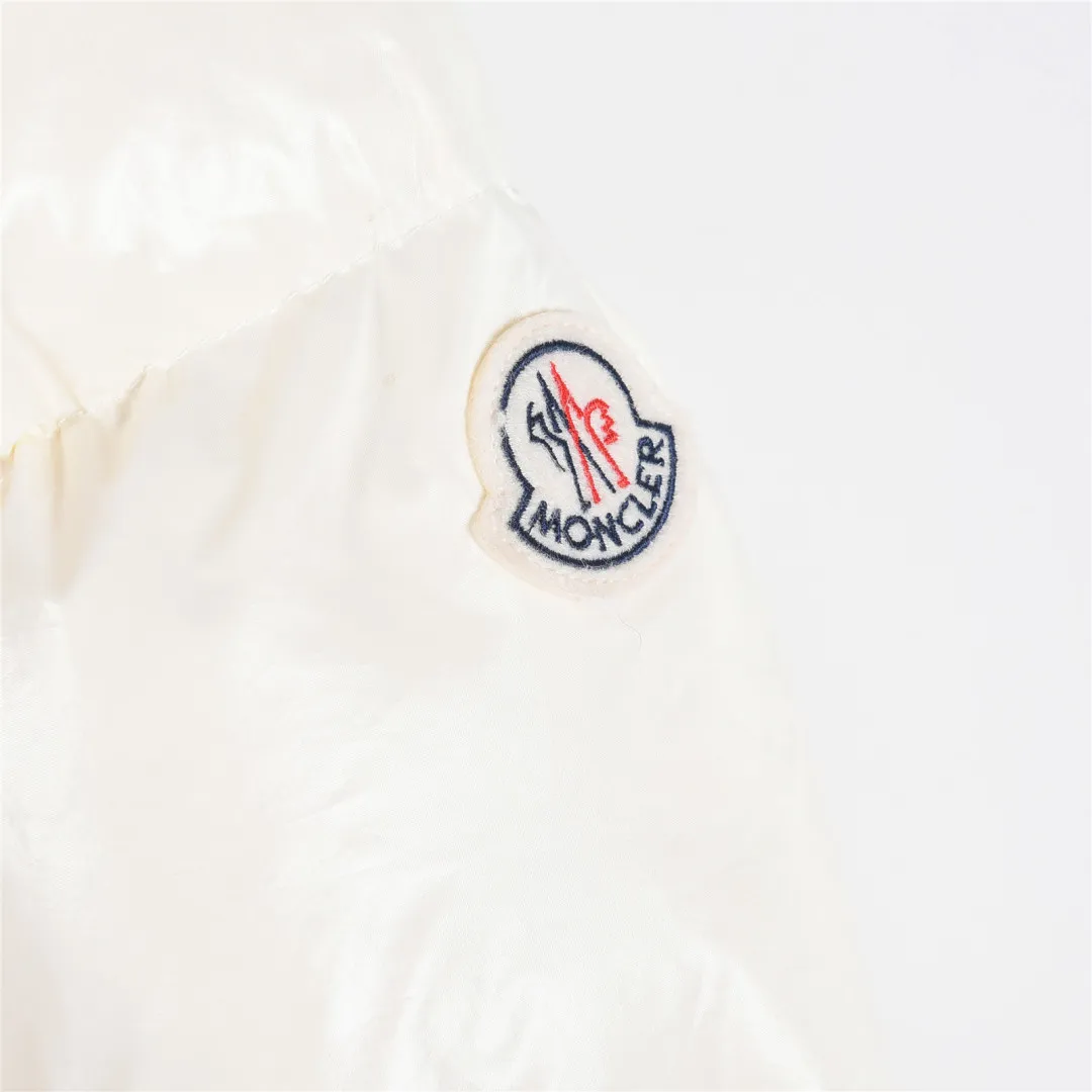 P860 Moncler / Moncler Mouth Small Waist Second Generation FW25 Glareins Woven Trim Hooded Short Comfort Down Jacket Women's Glareins Woven Trim Hooded Short Down Jacket is a classic item of Moncler's 2025 autumn and winter women's wear series. It highlights the feminine temperament with exquisite braided trim and waist design.  • Design highlights: Braided trim is used to highlight the waist silhouette, and the short hooded design is both fashionable and practical • Fabric technology: The outer shell is made of 100% nylon fabric, with a gorgeous luster, and the interior is filled with 90% white goose down + 10% feathers • Functional details: Equipped with an adjustable hood, zipper + snap button double closure, waist drawstring design, length of about 58cm • Origin information: Mainly made in Romania, ensuring European quality standards • Good upper body effect: A-line hem design with slightly closed waist, as delicate as a princess, outstanding proportion modification effect • Strong thermal insulation performance: 90 white goose down filling, warmth retention comparable to polar expedition equipment, light and not bulky • Strong sense of quality: high-quality hardware, even and fine stitching, clear brand logo Color: blue off-white black code number: 0 1 2 3