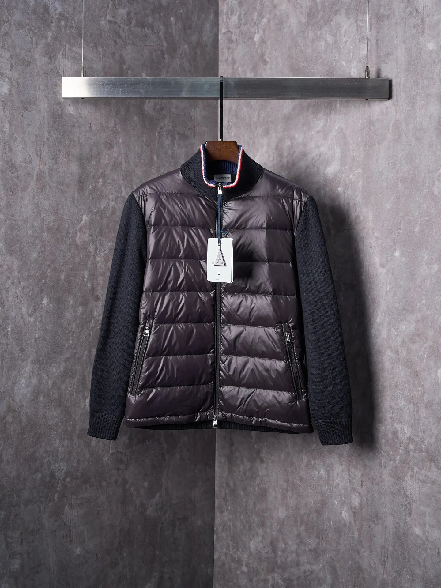 P820 ​​Actual hanging auction] MONCLER/Mask quilted wool splicing zipper three-color trim stand-up collar down jacket [Ready stock] 1 2 3 4 high-quality white duck down filling, with a filling capacity of 130g, excellent warmth retention effect.  The front body fabric is made of 100% polyester fiber with high-density weaving. The thickness of 0.08mm avoids increasing the overall weight and is smooth. The high-density weaving structure forms a wind resistance layer to protect the thermal efficiency of the thermal layer from loss. It can withstand the expansion pressure of down and prevent deformation and damage after long-term use.  7-needle medium-thick knitted structure: Use thicker yarns to knit woolen fabrics with obvious thickness and weight. The texture is clearly visible and has a rough, retro texture. It has a good skeleton feel, is relatively stiff, and can maintain the silhouette of clothing for a long time. It also provides more layers of still air to lock in heat.  The three-color trim at the collar draws traditional inspiration and becomes the finishing touch. Smooth pocket zipper closure enhances practicality and aesthetics.