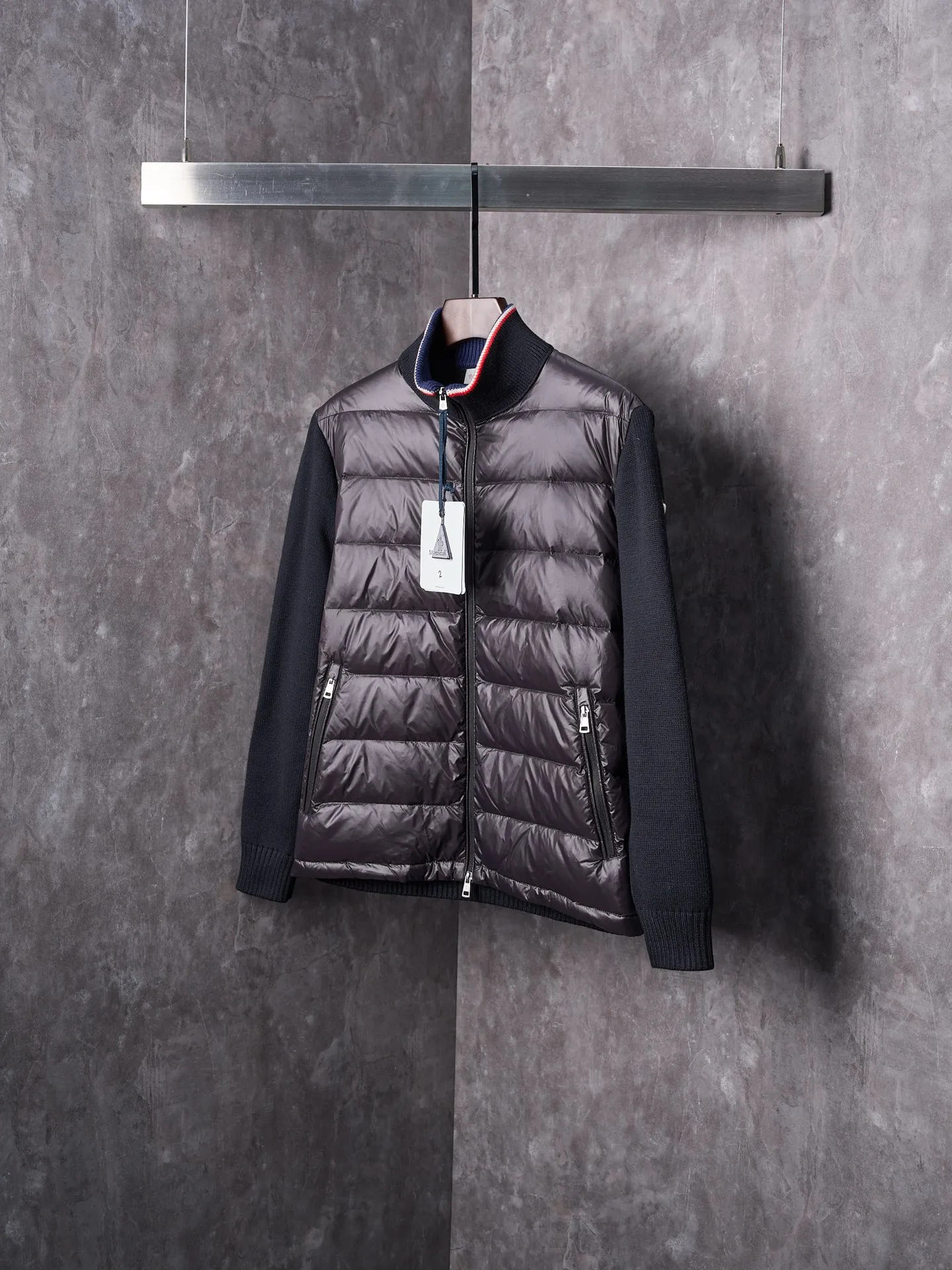 P820 ​​Actual hanging auction] MONCLER/Mask quilted wool splicing zipper three-color trim stand-up collar down jacket [Ready stock] 1 2 3 4 high-quality white duck down filling, with a filling capacity of 130g, excellent warmth retention effect.  The front body fabric is made of 100% polyester fiber with high-density weaving. The thickness of 0.08mm avoids increasing the overall weight and is smooth. The high-density weaving structure forms a wind resistance layer to protect the thermal efficiency of the thermal layer from loss. It can withstand the expansion pressure of down and prevent deformation and damage after long-term use.  7-needle medium-thick knitted structure: Use thicker yarns to knit woolen fabrics with obvious thickness and weight. The texture is clearly visible and has a rough, retro texture. It has a good skeleton feel, is relatively stiff, and can maintain the silhouette of clothing for a long time. It also provides more layers of still air to lock in heat.  The three-color trim at the collar draws traditional inspiration and becomes the finishing touch. Smooth pocket zipper closure enhances practicality and aesthetics.