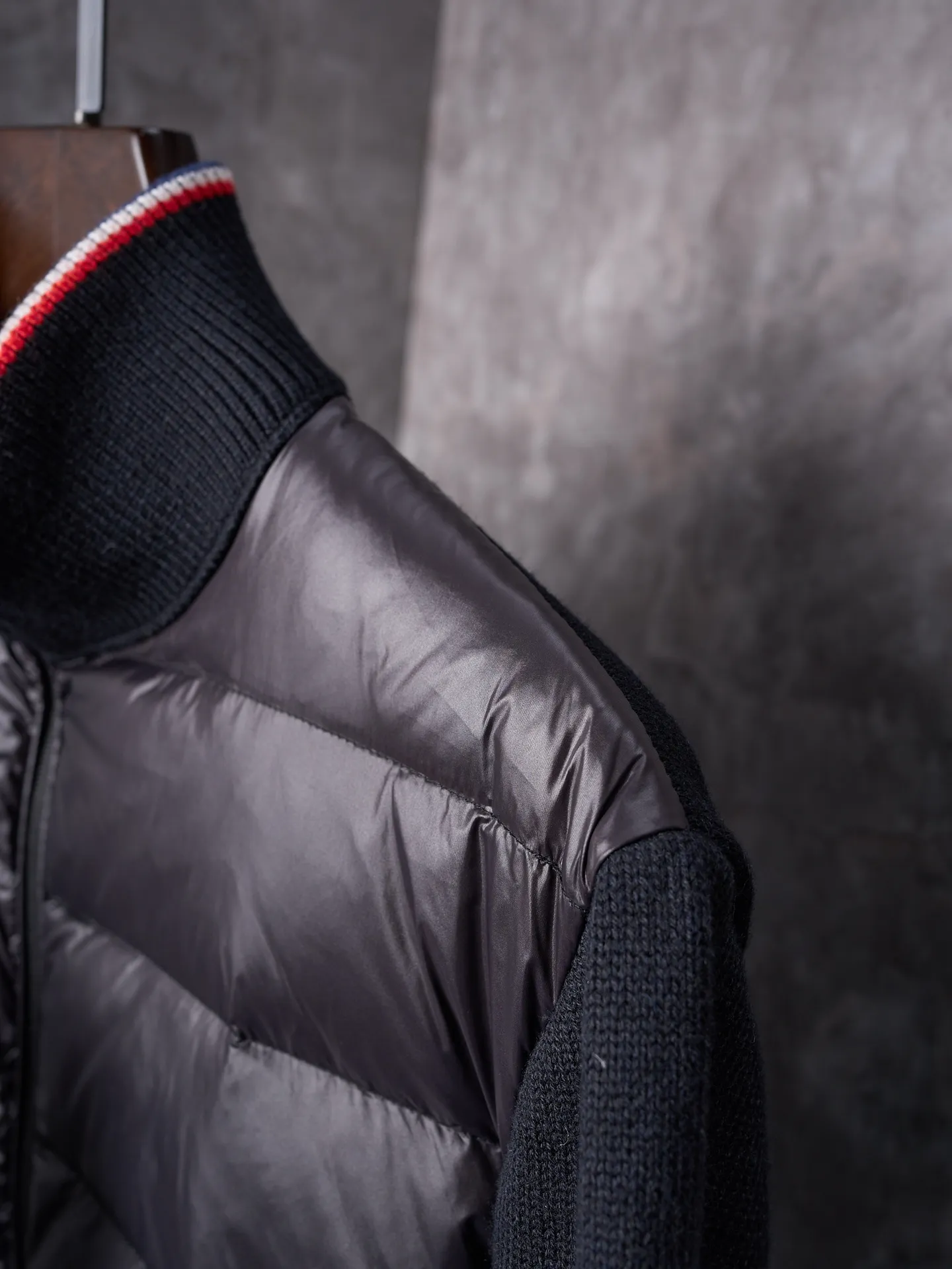 P820 ​​Actual hanging auction] MONCLER/Mask quilted wool splicing zipper three-color trim stand-up collar down jacket [Ready stock] 1 2 3 4 high-quality white duck down filling, with a filling capacity of 130g, excellent warmth retention effect.  The front body fabric is made of 100% polyester fiber with high-density weaving. The thickness of 0.08mm avoids increasing the overall weight and is smooth. The high-density weaving structure forms a wind resistance layer to protect the thermal efficiency of the thermal layer from loss. It can withstand the expansion pressure of down and prevent deformation and damage after long-term use.  7-needle medium-thick knitted structure: Use thicker yarns to knit woolen fabrics with obvious thickness and weight. The texture is clearly visible and has a rough, retro texture. It has a good skeleton feel, is relatively stiff, and can maintain the silhouette of clothing for a long time. It also provides more layers of still air to lock in heat.  The three-color trim at the collar draws traditional inspiration and becomes the finishing touch. Smooth pocket zipper closure enhances practicality and aesthetics.