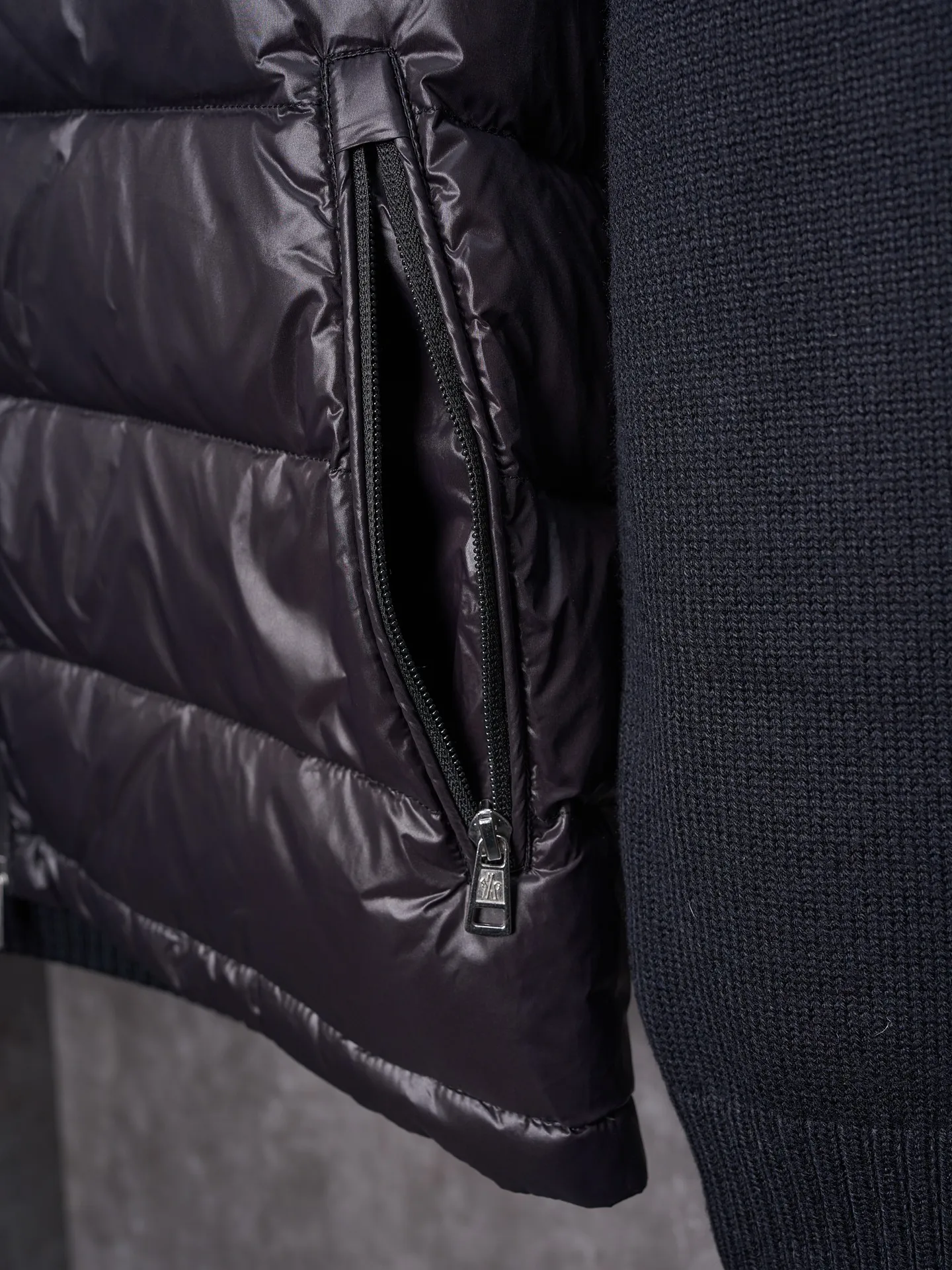 P820 ​​Actual hanging auction] MONCLER/Mask quilted wool splicing zipper three-color trim stand-up collar down jacket [Ready stock] 1 2 3 4 high-quality white duck down filling, with a filling capacity of 130g, excellent warmth retention effect.  The front body fabric is made of 100% polyester fiber with high-density weaving. The thickness of 0.08mm avoids increasing the overall weight and is smooth. The high-density weaving structure forms a wind resistance layer to protect the thermal efficiency of the thermal layer from loss. It can withstand the expansion pressure of down and prevent deformation and damage after long-term use.  7-needle medium-thick knitted structure: Use thicker yarns to knit woolen fabrics with obvious thickness and weight. The texture is clearly visible and has a rough, retro texture. It has a good skeleton feel, is relatively stiff, and can maintain the silhouette of clothing for a long time. It also provides more layers of still air to lock in heat.  The three-color trim at the collar draws traditional inspiration and becomes the finishing touch. Smooth pocket zipper closure enhances practicality and aesthetics.