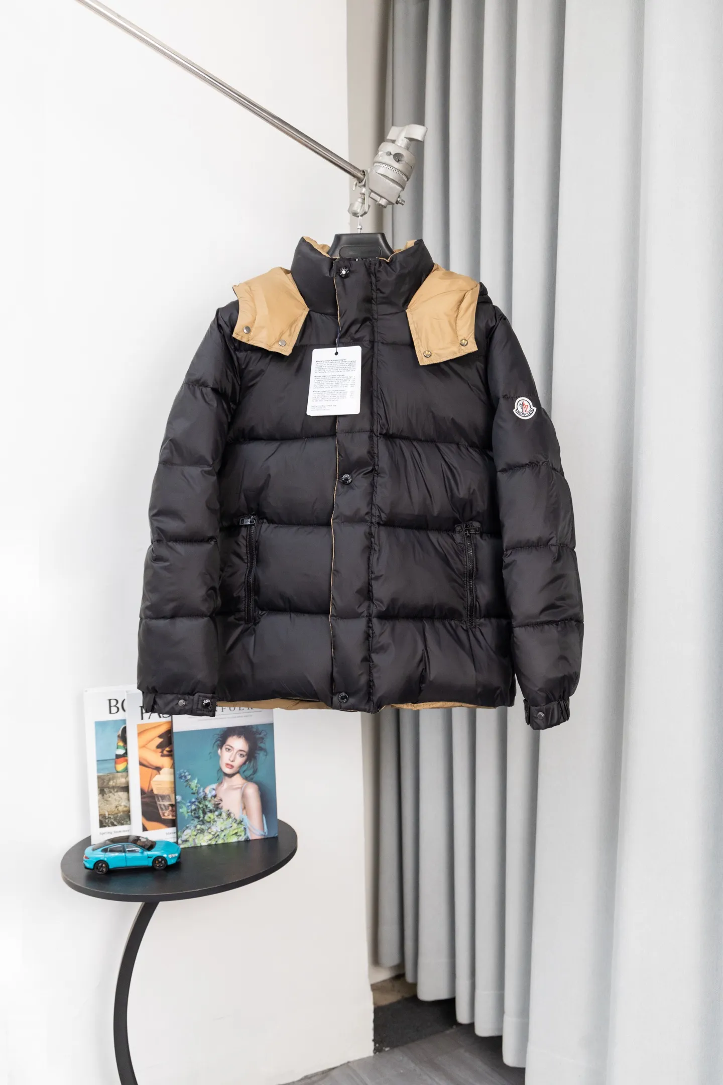 P570 model number: S038 Moncler Parana series is a classic item of the brand that combines retro style with modern functionality. It continues Moncler’s iconic felt badges on sleeves and arms, low-key highlighting the brand identity, and is the core embodiment of luxury recognition. The design is inspired by the "Paninaro culture" of the 1980s, paying tribute to classics with glossy materials and retro silhouettes, while injecting modern street trend genes to achieve a collision of retro and avant-garde styles. Fabric: Made of the brand's exclusive high-gloss lacquered nylon (Nylon laqué), which has anti-fouling and anti-static properties. The glossy texture is visually impactful and can effectively reflect light, making the outfit more eye-catching. It has strong warmth retention while maintaining a light body feel, achieving a "warm and burden-free" wearing experience.  Detachable hood: The hood is designed with khaki color splicing to form a visual contrast with the black main body; it can be flexibly detached according to weather and styling needs, adapting to a variety of scenes.  Double closure system: The front placket adopts a "zipper + snap button" combination, which improves wind resistance and warmth while enhancing the layering of the style. Detailed configuration: Zipper pockets on both sides are practical and decorative, elastic cuffs can lock in temperature, and the drawstring design on the hem can adjust the silhouette according to the body shape, reflecting humanized functionality at every turn. The loose version of the same style for men and women is highly tolerant to the body and is a high-quality choice for couples. It can easily realize the style expression of "high-end couple wear" and is suitable for daily commuting, outdoor leisure and other diverse scenes. Size: S-XL