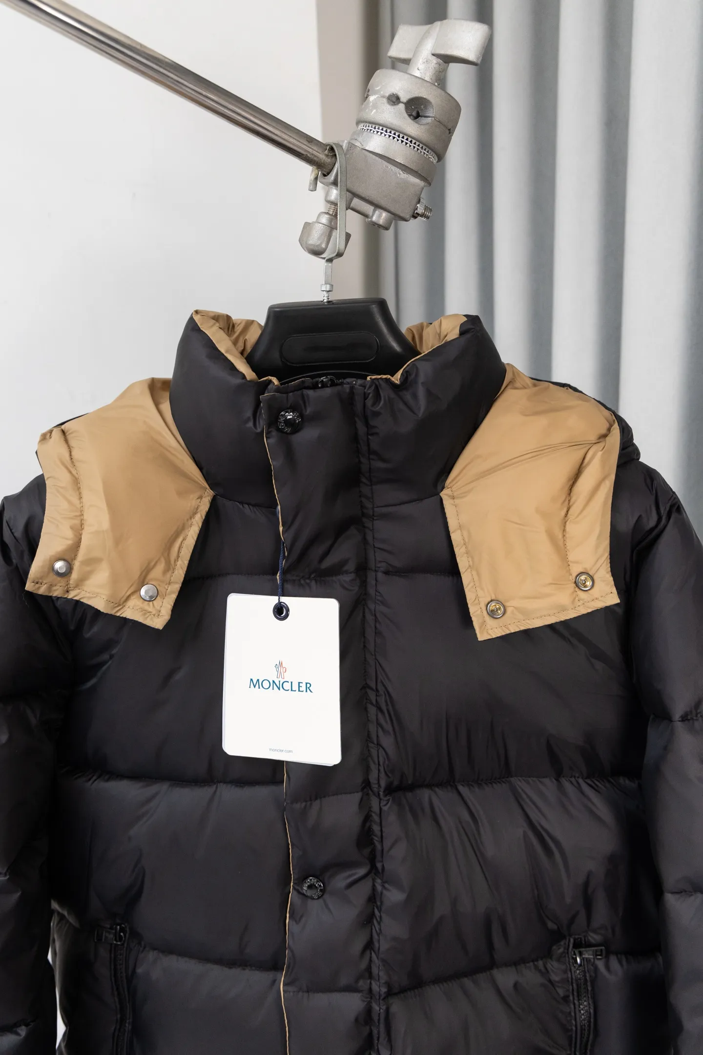 P570 model number: S038 Moncler Parana series is a classic item of the brand that combines retro style with modern functionality. It continues Moncler’s iconic felt badges on sleeves and arms, low-key highlighting the brand identity, and is the core embodiment of luxury recognition. The design is inspired by the "Paninaro culture" of the 1980s, paying tribute to classics with glossy materials and retro silhouettes, while injecting modern street trend genes to achieve a collision of retro and avant-garde styles. Fabric: Made of the brand's exclusive high-gloss lacquered nylon (Nylon laqué), which has anti-fouling and anti-static properties. The glossy texture is visually impactful and can effectively reflect light, making the outfit more eye-catching. It has strong warmth retention while maintaining a light body feel, achieving a "warm and burden-free" wearing experience.  Detachable hood: The hood is designed with khaki color splicing to form a visual contrast with the black main body; it can be flexibly detached according to weather and styling needs, adapting to a variety of scenes.  Double closure system: The front placket adopts a "zipper + snap button" combination, which improves wind resistance and warmth while enhancing the layering of the style. Detailed configuration: Zipper pockets on both sides are practical and decorative, elastic cuffs can lock in temperature, and the drawstring design on the hem can adjust the silhouette according to the body shape, reflecting humanized functionality at every turn. The loose version of the same style for men and women is highly tolerant to the body and is a high-quality choice for couples. It can easily realize the style expression of "high-end couple wear" and is suitable for daily commuting, outdoor leisure and other diverse scenes. Size: S-XL