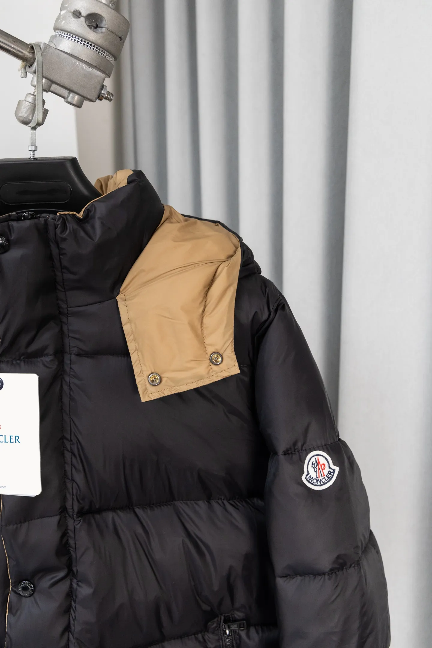 P570 model number: S038 Moncler Parana series is a classic item of the brand that combines retro style with modern functionality. It continues Moncler’s iconic felt badges on sleeves and arms, low-key highlighting the brand identity, and is the core embodiment of luxury recognition. The design is inspired by the "Paninaro culture" of the 1980s, paying tribute to classics with glossy materials and retro silhouettes, while injecting modern street trend genes to achieve a collision of retro and avant-garde styles. Fabric: Made of the brand's exclusive high-gloss lacquered nylon (Nylon laqué), which has anti-fouling and anti-static properties. The glossy texture is visually impactful and can effectively reflect light, making the outfit more eye-catching. It has strong warmth retention while maintaining a light body feel, achieving a "warm and burden-free" wearing experience.  Detachable hood: The hood is designed with khaki color splicing to form a visual contrast with the black main body; it can be flexibly detached according to weather and styling needs, adapting to a variety of scenes.  Double closure system: The front placket adopts a "zipper + snap button" combination, which improves wind resistance and warmth while enhancing the layering of the style. Detailed configuration: Zipper pockets on both sides are practical and decorative, elastic cuffs can lock in temperature, and the drawstring design on the hem can adjust the silhouette according to the body shape, reflecting humanized functionality at every turn. The loose version of the same style for men and women is highly tolerant to the body and is a high-quality choice for couples. It can easily realize the style expression of "high-end couple wear" and is suitable for daily commuting, outdoor leisure and other diverse scenes. Size: S-XL