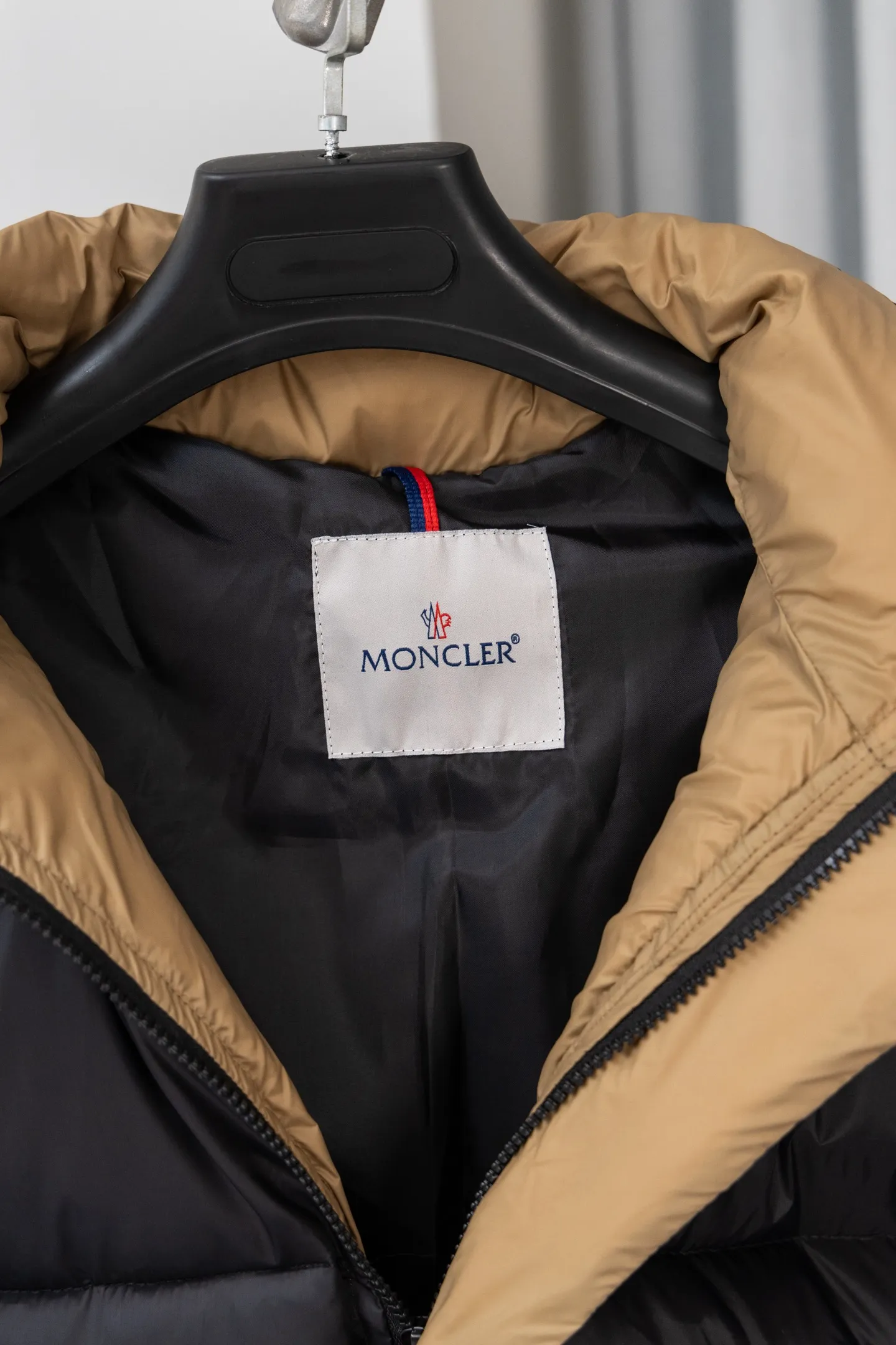 P570 model number: S038 Moncler Parana series is a classic item of the brand that combines retro style with modern functionality. It continues Moncler’s iconic felt badges on sleeves and arms, low-key highlighting the brand identity, and is the core embodiment of luxury recognition. The design is inspired by the "Paninaro culture" of the 1980s, paying tribute to classics with glossy materials and retro silhouettes, while injecting modern street trend genes to achieve a collision of retro and avant-garde styles. Fabric: Made of the brand's exclusive high-gloss lacquered nylon (Nylon laqué), which has anti-fouling and anti-static properties. The glossy texture is visually impactful and can effectively reflect light, making the outfit more eye-catching. It has strong warmth retention while maintaining a light body feel, achieving a "warm and burden-free" wearing experience.  Detachable hood: The hood is designed with khaki color splicing to form a visual contrast with the black main body; it can be flexibly detached according to weather and styling needs, adapting to a variety of scenes.  Double closure system: The front placket adopts a "zipper + snap button" combination, which improves wind resistance and warmth while enhancing the layering of the style. Detailed configuration: Zipper pockets on both sides are practical and decorative, elastic cuffs can lock in temperature, and the drawstring design on the hem can adjust the silhouette according to the body shape, reflecting humanized functionality at every turn. The loose version of the same style for men and women is highly tolerant to the body and is a high-quality choice for couples. It can easily realize the style expression of "high-end couple wear" and is suitable for daily commuting, outdoor leisure and other diverse scenes. Size: S-XL
