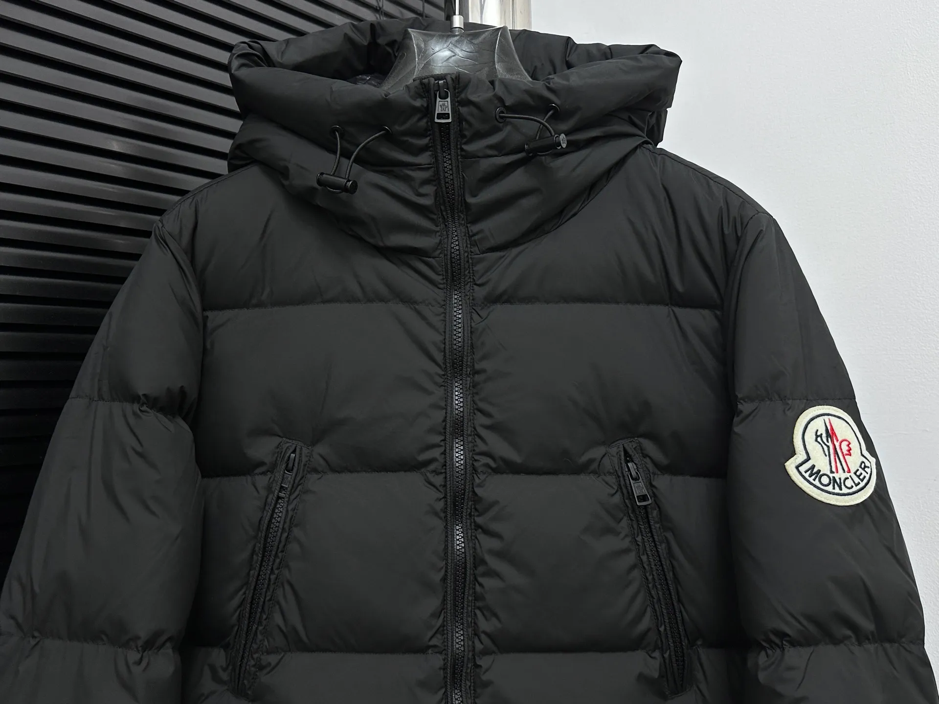 P1100 [Moncler] Bosona mid-length large felt badge down. Popular style. Good-looking for both men and women. This Bosona men's long down combines Moncler's classic aesthetics, excellent performance and protective features. Bosona long down is made of longue saison fabric and is designed with practical details to provide both warmth and protection. As a Moncler classic, this down jacket features a detachable hood and a front zipper placket that covers the windshield, significantly improving its protective performance. Size: 1-4
