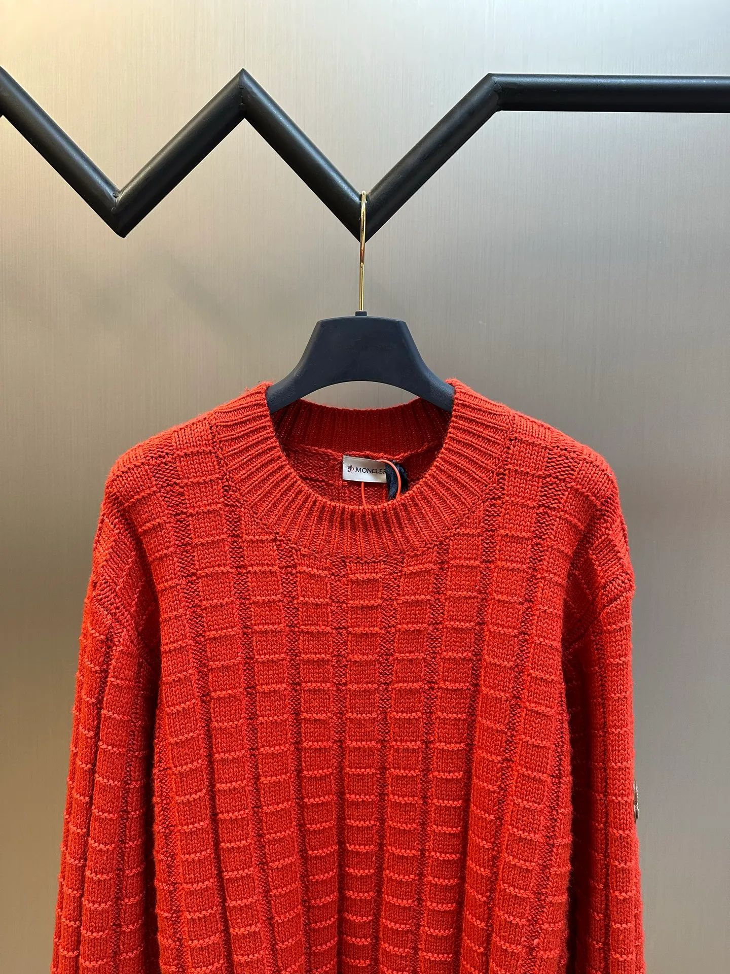 P430 Moncler embossed knitted logo sweater is made of custom-woven engraved wool texture, with three-dimensional texture as the brushstrokes. The entire embossed knitting reconstructs the dimension of knitted aesthetics. It produces a light and dark gradient texture halo as the human body moves. The iconic Moncler logo embroidered logo decorates the sleeves, making it highly recognizable.  The whole piece of embossed vertical grain knitting uses specific stitches and changes in fabric structure, and changes the arrangement of stitches and the density of the fabric, so that the vertical grains present a relief effect that is raised on the surface of the sweater, forming undulating changes in the vertical grains.  Curved thread structure, by changing the stitching method and the arrangement of yarns during the knitting process, makes the yarns present a curved distribution in the fabric.  size：s m l xl