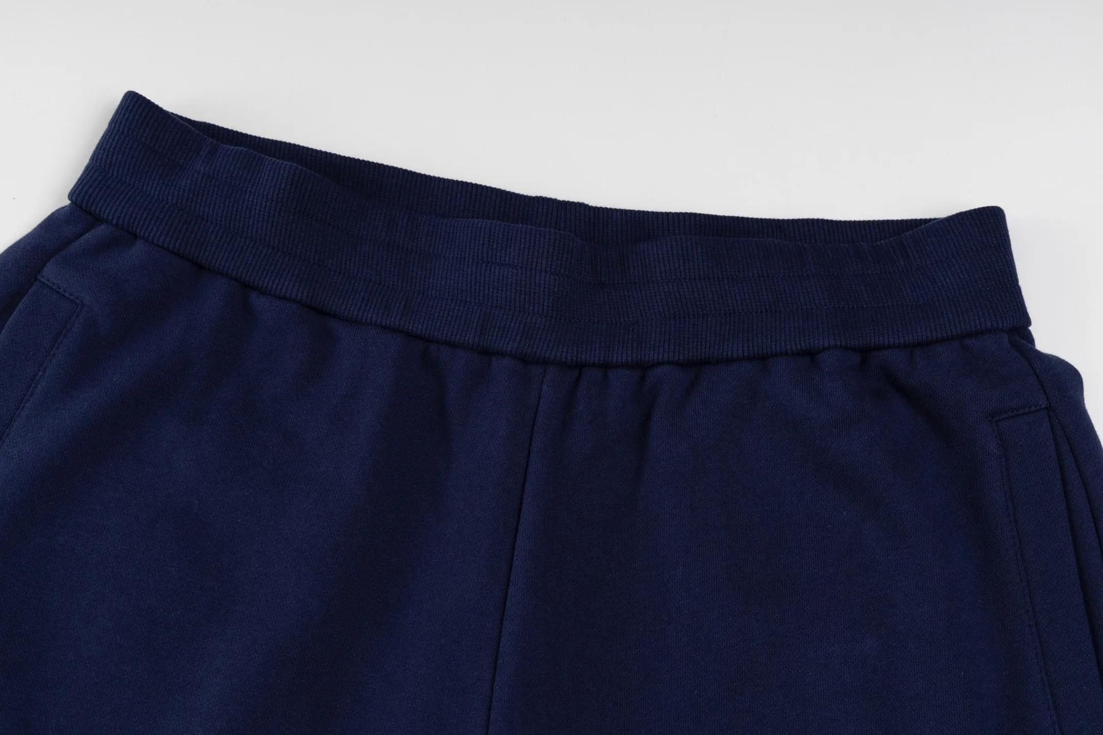 P300 [Exclusive supply] Moncler Mouthless Three-Party Joint Shorts (Navy Blue) The fabric is made of single-sided fish-scale fabric woven with cotton as the base. The front is a smooth knitted surface, and the skin-contacting surface is formed into three-dimensional terry through the floating knitting technology of the knitting machine, which increases the fluffiness and has a delicate touch. The terry structure absorbs a large amount of water and evaporates quickly, so it is not easy to loosen and deform after repeated washing. The letters LOGO are embroidered on the back panel using 16,000 needles + 18,000 needles on the embroidery machine. The double-axis linear guide drives the embroidery frame, and the frame moving accuracy can reach 0.01mm/P, ensuring precise positioning of the embroidery pattern. By actively interfering with the shrinkage potential of cotton fibers, the fabric is able to transition from changeable to stable, improving dimensional stability while being less prone to deformation and wrinkles. Size:S-M-L-XL