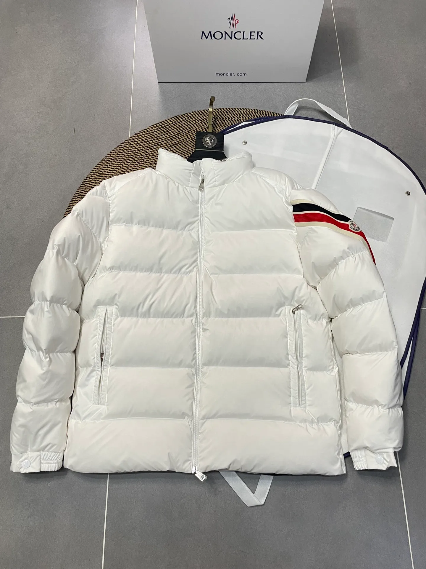 P840 🆕❤️2️⃣0️⃣2️⃣4️⃣🆕Premium down⬆️Moncler Solayan men's three-color trim short down jacket. Premium goose down filling. The finest, lightest and neatest fabric. Solayan men's short down jacket is decorated with seasonal iconic stripe details, blending sportsmanship and timeless style.  The Solayan down jacket is made of micro chic fabric and has a tough square shape design, highlighting Moncler's sporty spirit. This cropped down jacket features tricolor stripes on the sleeves, a seasonal take on the brand's signature. Comes with a practical pull-out hood. Details •Made from micro chic nylon fabric •Micro chic nylon lining •Down filled •Pull-out hood •Zip closure •Zip pockets •Adjustable cuffs •Elastic drawstring hem •Tri-color trim on sleeves Size: 1-5 Color: White Dark Brown Black