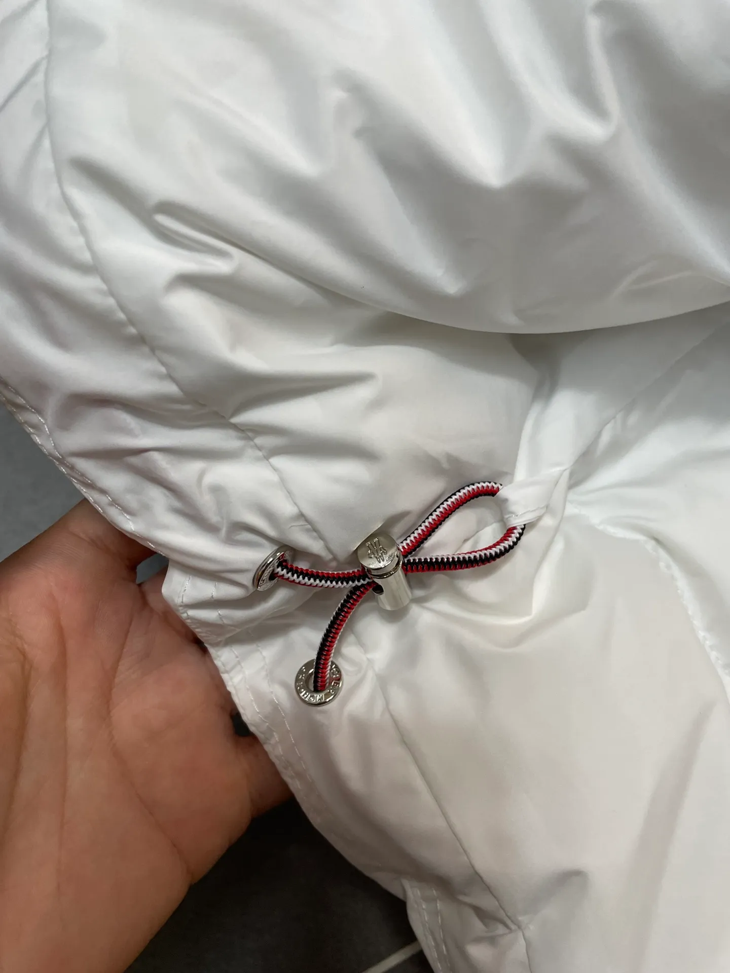 P840 🆕❤️2️⃣0️⃣2️⃣4️⃣🆕Premium down⬆️Moncler Solayan men's three-color trim short down jacket. Premium goose down filling. The finest, lightest and neatest fabric. Solayan men's short down jacket is decorated with seasonal iconic stripe details, blending sportsmanship and timeless style.  The Solayan down jacket is made of micro chic fabric and has a tough square shape design, highlighting Moncler's sporty spirit. This cropped down jacket features tricolor stripes on the sleeves, a seasonal take on the brand's signature. Comes with a practical pull-out hood. Details •Made from micro chic nylon fabric •Micro chic nylon lining •Down filled •Pull-out hood •Zip closure •Zip pockets •Adjustable cuffs •Elastic drawstring hem •Tri-color trim on sleeves Size: 1-5 Color: White Dark Brown Black