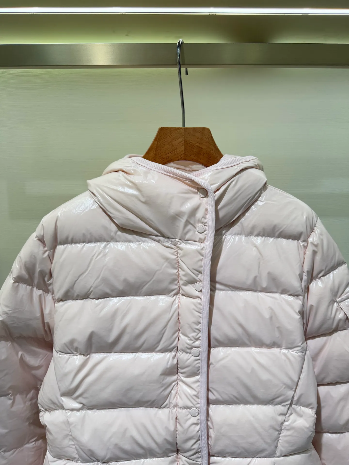 P1140 Moncler Barante series short waisted down jacket. The Barante down jacket is made of glossy nylon fabric and is inspired by the 1970s. The short version features a nipped-in waist and an A-line silhouette, highlighting a feminine style. An adjustable hood and signature logo patch add finishing touches.  Fabric: Made of nylon laque fabric, Nylon laque lining, filled with down (90 white goose down) Craftsmanship: Adjustable hood, zipper and snap closure, zipper pocket Adjustable cuffs (supports NFC function Color: black pink off-white Size: 0 1 2 3 4446080
