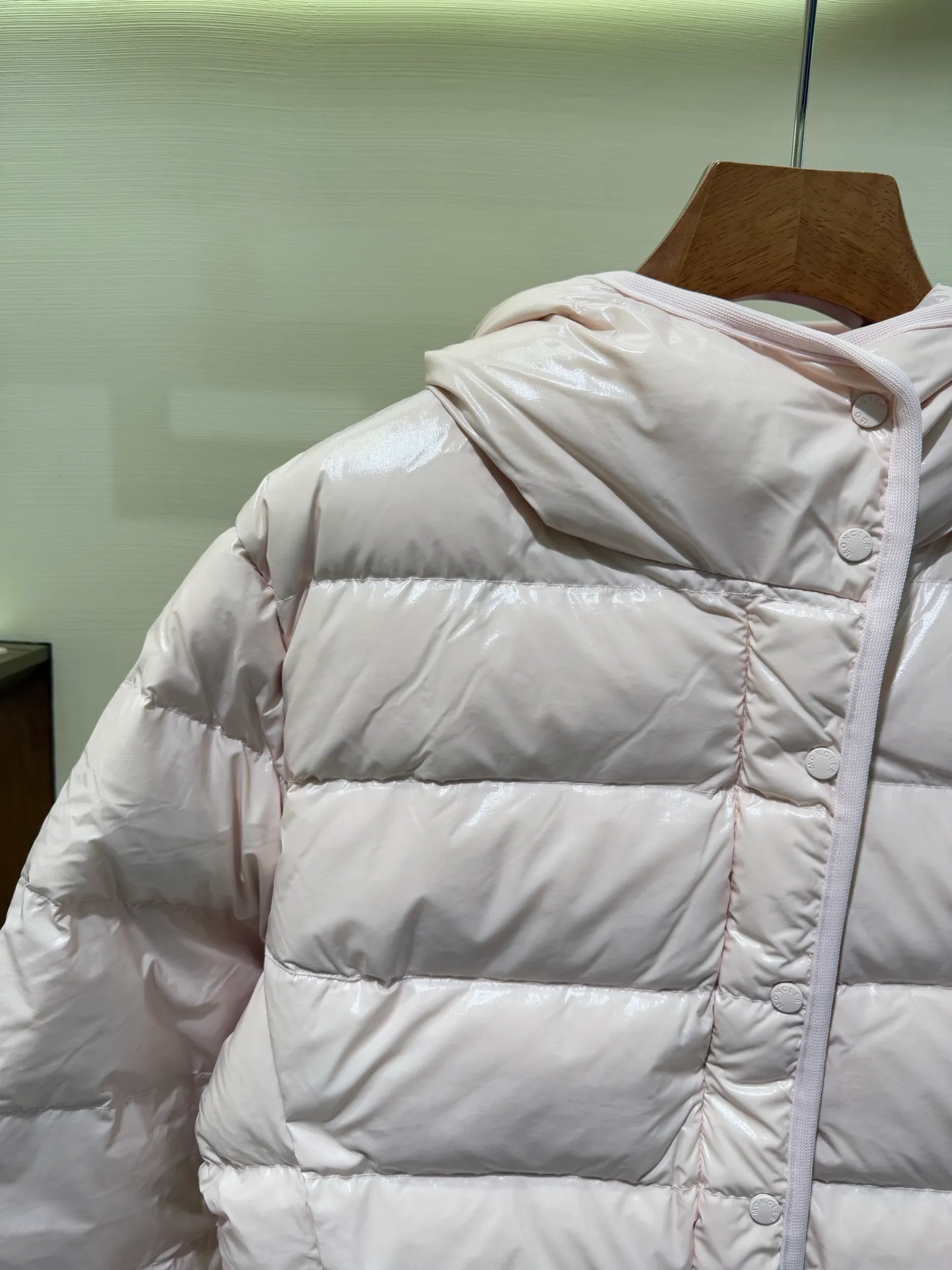 P1140 Moncler Barante series short waisted down jacket. The Barante down jacket is made of glossy nylon fabric and is inspired by the 1970s. The short version features a nipped-in waist and an A-line silhouette, highlighting a feminine style. An adjustable hood and signature logo patch add finishing touches.  Fabric: Made of nylon laque fabric, Nylon laque lining, filled with down (90 white goose down) Craftsmanship: Adjustable hood, zipper and snap closure, zipper pocket Adjustable cuffs (supports NFC function Color: black pink off-white Size: 0 1 2 3 4446080