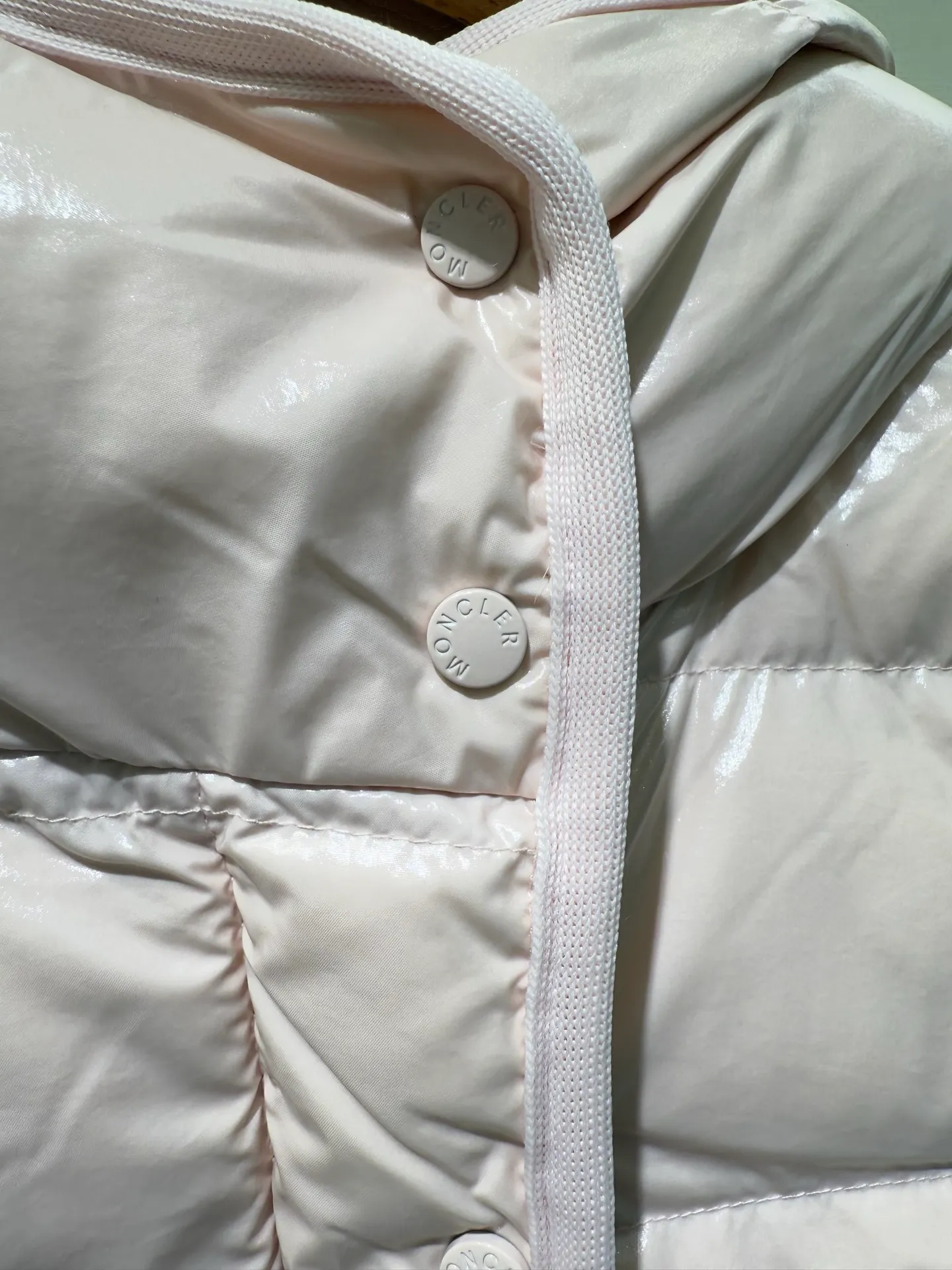 P1140 Moncler Barante series short waisted down jacket. The Barante down jacket is made of glossy nylon fabric and is inspired by the 1970s. The short version features a nipped-in waist and an A-line silhouette, highlighting a feminine style. An adjustable hood and signature logo patch add finishing touches.  Fabric: Made of nylon laque fabric, Nylon laque lining, filled with down (90 white goose down) Craftsmanship: Adjustable hood, zipper and snap closure, zipper pocket Adjustable cuffs (supports NFC function Color: black pink off-white Size: 0 1 2 3 4446080