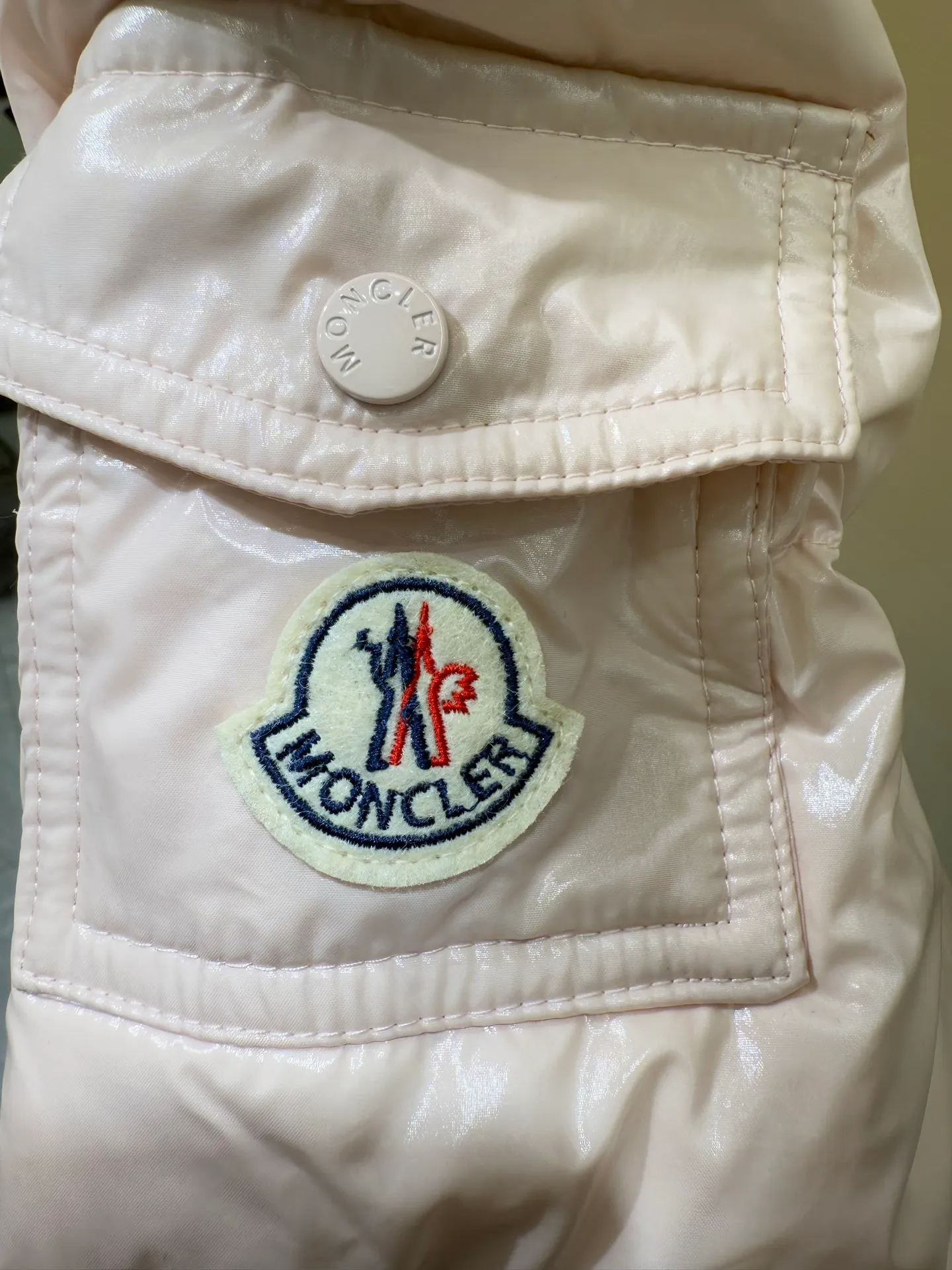 P1140 Moncler Barante series short waisted down jacket. The Barante down jacket is made of glossy nylon fabric and is inspired by the 1970s. The short version features a nipped-in waist and an A-line silhouette, highlighting a feminine style. An adjustable hood and signature logo patch add finishing touches.  Fabric: Made of nylon laque fabric, Nylon laque lining, filled with down (90 white goose down) Craftsmanship: Adjustable hood, zipper and snap closure, zipper pocket Adjustable cuffs (supports NFC function Color: black pink off-white Size: 0 1 2 3 4446080