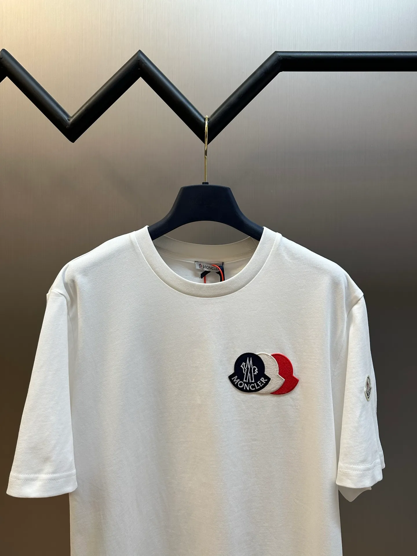 P230 Moncler short-sleeved patch logo, custom-made cloud-soft plain cotton fabric, with the iconic three-color design badge embellished on the chest, interpreting the visual grammar of modern luxury, and the Moncler embroidered logo on the side, highlighting the brand style.  Using imported machine embroidery technology, advanced computer control systems and precision mechanical components, Moncler embroidery logo embroidery operations are realized.  size：s m l xl