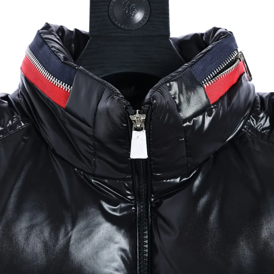 P700 Moncler Mouth 23FW New Men's Stand Collar Invisible Hood Down Vest Color: The vest is black, indicating that it has a classic and low-key appearance. Material: Made of high-quality 90 velvet fabric, which guarantees its quality and durability. Warmth: Since it is a down vest, warmth should be one of its important features. Down is an excellent thermal insulation material and can provide good thermal insulation effect. Design Features: It has a red collar and black zipper pockets, which add bright color and practical functionality to the vest. The red collar can attract attention and add a touch of brightness to the overall look; the white zipper pocket is convenient for carrying various items, increasing its practicality. Purpose: This vest is suitable for outdoor wear, as can be inferred from the description. It comes with a white label indicating that it is an outdoor garment and is intended to be worn during outdoor activities. Wearing experience: Wearing this down vest, you can enjoy a free and relaxed feeling outdoors. This shows that it has a comfortable wearing experience and is suitable for various outdoor activities. 003 Size:1-5
