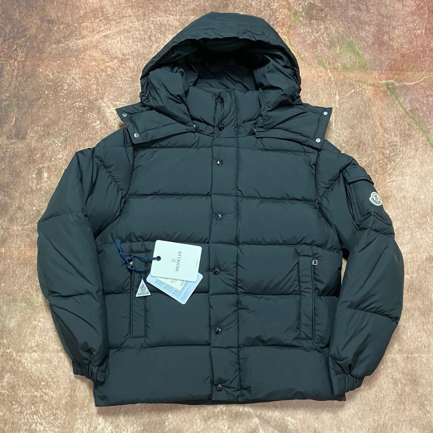 P840 MONCLER matte Maya down jacket. Process description: Made of the brand's iconic longue saison fabric, it has both light texture and excellent thermal insulation performance. This unisex down jacket has a matte appearance and is lined with lon léger brillant material to ensure comfort. Its core filling is 90% high-quality goose down, with a down filling capacity of 204 grams, providing excellent thermal insulation effect. The design continues the classic elements of Moner, with the short silhouette and sleeve patch pocket details paying tribute to the Maya series. In terms of functionality, it is equipped with a detachable and adjustable hood, a dual zipper and snap button opening system, and a zipper pocket to enhance practicality. The sleeves are specially designed with adjustable cuffs and a drawstring hem design, so you can freely adjust the tightness according to your needs. The overall craftsmanship is exquisite, which not only retains Moner's consistent fashion genes, but also enhances the convenience of daily wear through exquisite detail processing. ⚠️Color: Black ⚠️Size: 12345