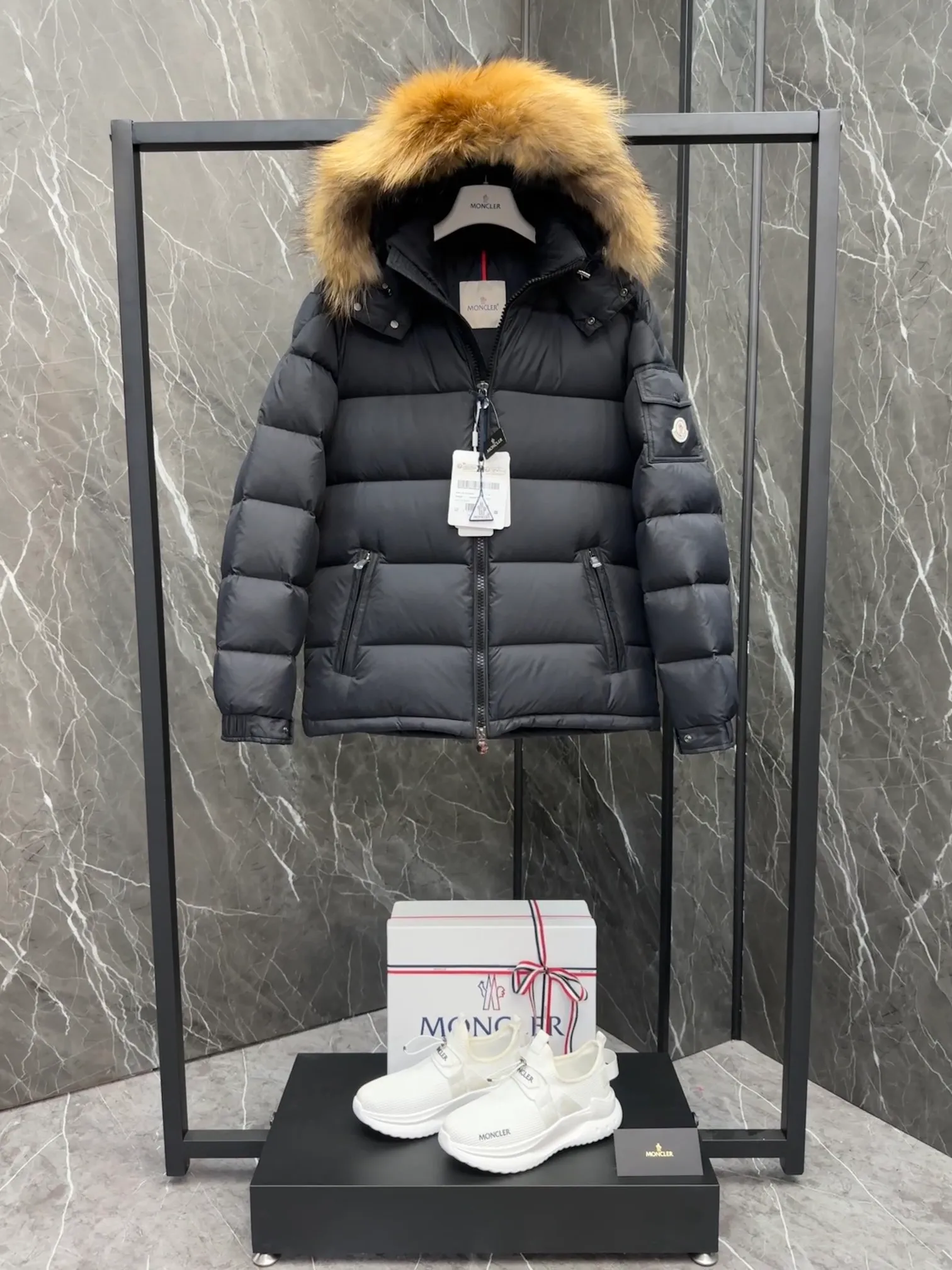P1040 ⬆️Moncler Mayaf short men's down jacket. The hood is removable. The fur collar is removable. Based on Maya, a removable fur collar is added. The Mayaf men's hooded down jacket is made of functional nylon fabric, and the hood is equipped with removable synthetic material trim.  The Mayaf short down jacket is a reinterpretation of the classic Moncler Maya style in an instantly recognizable silhouette, with a removable hood and adjustable hem. Made from functional fabric with removable synthetic trim on the hood. The sleeves are embellished with classic patch pockets, reflecting the brand's signature style. Details •Made from functional fabric •Technical fabric lining •Down-filled •Push-stud collar •Detachable hood with removable synthetic trim •Zip closure •Zip pockets •Patch pockets with press-stud •Adjustable elastic cuffs •Adjustable drawstring hem