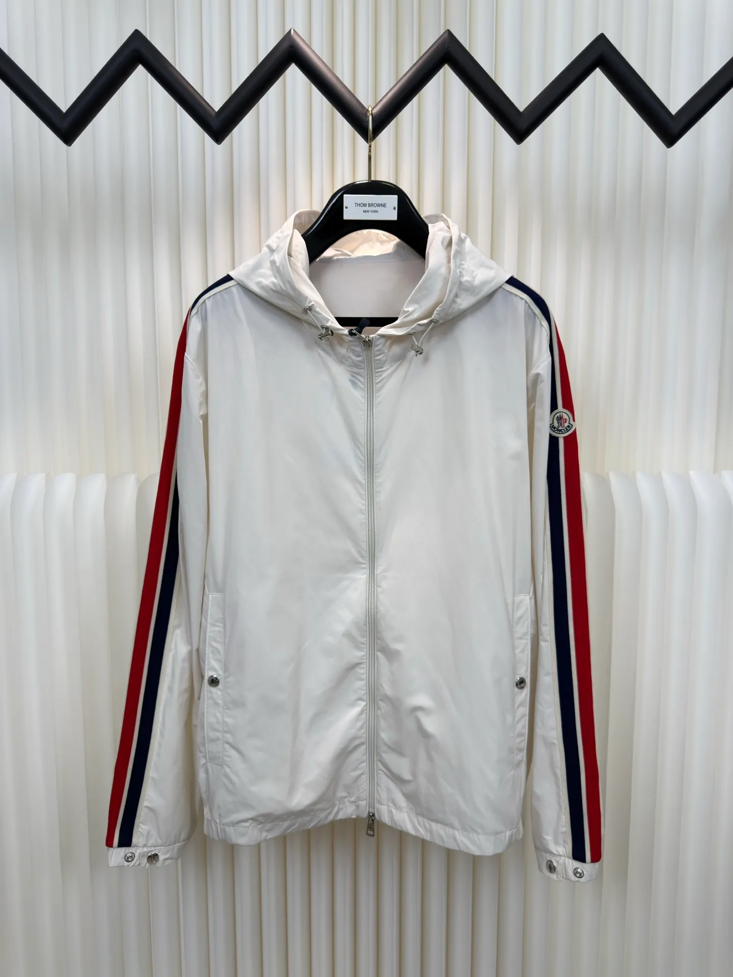 P570 MONCLER lightweight jacket with web trim at the mouth is made of 100% polyester fiber to create a tough protective outer layer. It is famous for its excellent tear resistance and wear resistance. It can quickly return to flatness during wearing and maintain the crisp and stylish appearance of the clothing for a long time. At the same time, it is not easy to deform after being washed for a long time.  Decorative edging in two different colors has been added to the center section of the sleeves. This design element not only adds visual highlights to clothing, making it more fashionable and unique. The webbing is precisely positioned along the cuffs to the seam of the collar and hat to ensure symmetry and overall smoothness. Before actual sewing, use very fine basting stitches for pre-fixing. This step is crucial to prevent the webbing from slipping, twisting, or wrinkling during sewing and ensuring that the final stitch is straight and perfect. Size 1 2 3 4