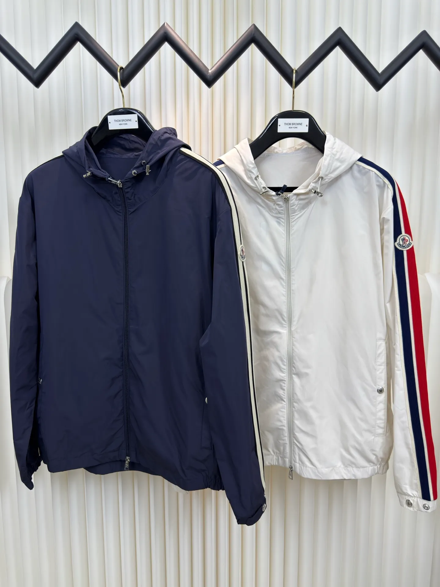 P570 MONCLER lightweight jacket with web trim at the mouth is made of 100% polyester fiber to create a tough protective outer layer. It is famous for its excellent tear resistance and wear resistance. It can quickly return to flatness during wearing and maintain the crisp and stylish appearance of the clothing for a long time. At the same time, it is not easy to deform after being washed for a long time.  Decorative edging in two different colors has been added to the center section of the sleeves. This design element not only adds visual highlights to clothing, making it more fashionable and unique. The webbing is precisely positioned along the cuffs to the seam of the collar and hat to ensure symmetry and overall smoothness. Before actual sewing, use very fine basting stitches for pre-fixing. This step is crucial to prevent the webbing from slipping, twisting, or wrinkling during sewing and ensuring that the final stitch is straight and perfect. Size 1 2 3 4