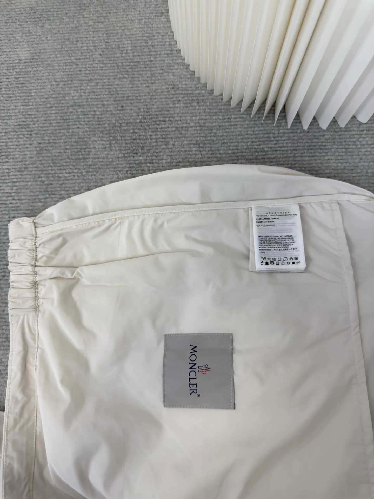P570 MONCLER lightweight jacket with web trim at the mouth is made of 100% polyester fiber to create a tough protective outer layer. It is famous for its excellent tear resistance and wear resistance. It can quickly return to flatness during wearing and maintain the crisp and stylish appearance of the clothing for a long time. At the same time, it is not easy to deform after being washed for a long time.  Decorative edging in two different colors has been added to the center section of the sleeves. This design element not only adds visual highlights to clothing, making it more fashionable and unique. The webbing is precisely positioned along the cuffs to the seam of the collar and hat to ensure symmetry and overall smoothness. Before actual sewing, use very fine basting stitches for pre-fixing. This step is crucial to prevent the webbing from slipping, twisting, or wrinkling during sewing and ensuring that the final stitch is straight and perfect. Size 1 2 3 4