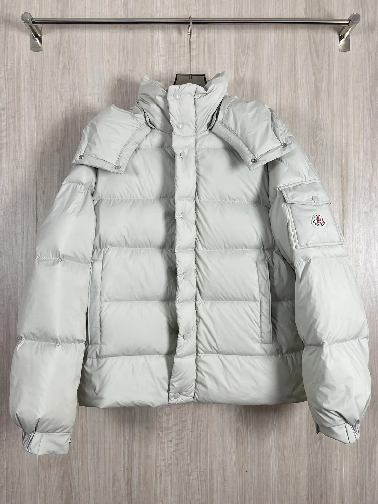 P1320 Moncler Maya 70 winter limited edition matte gray and white down jacket jacket Moncler Maya short down jacket is presented in a new color. Made from matte fabric and featuring signature checkered quilting, it reflects the essence of the Moncler brand. The style features a sharp silhouette with a detachable hood and adjustable hem in a timeless design suitable for every season and trend. The sleeves are embellished with classic patch pockets, and the down jacket is suitable for both men and women.  Fabric: 100% polyester fiber; Lining: 100% polyester fiber; Filling: 95 white duck down Craftsmanship: Made of polyester fiber fabric, polyester fiber lining, filled with down, detachable and adjustable hood, zipper closure, front windshield with snap buttons, zipper pockets, adjustable cuffs, elastic drawstring hem Size: 1 2 3 4 5 0555070