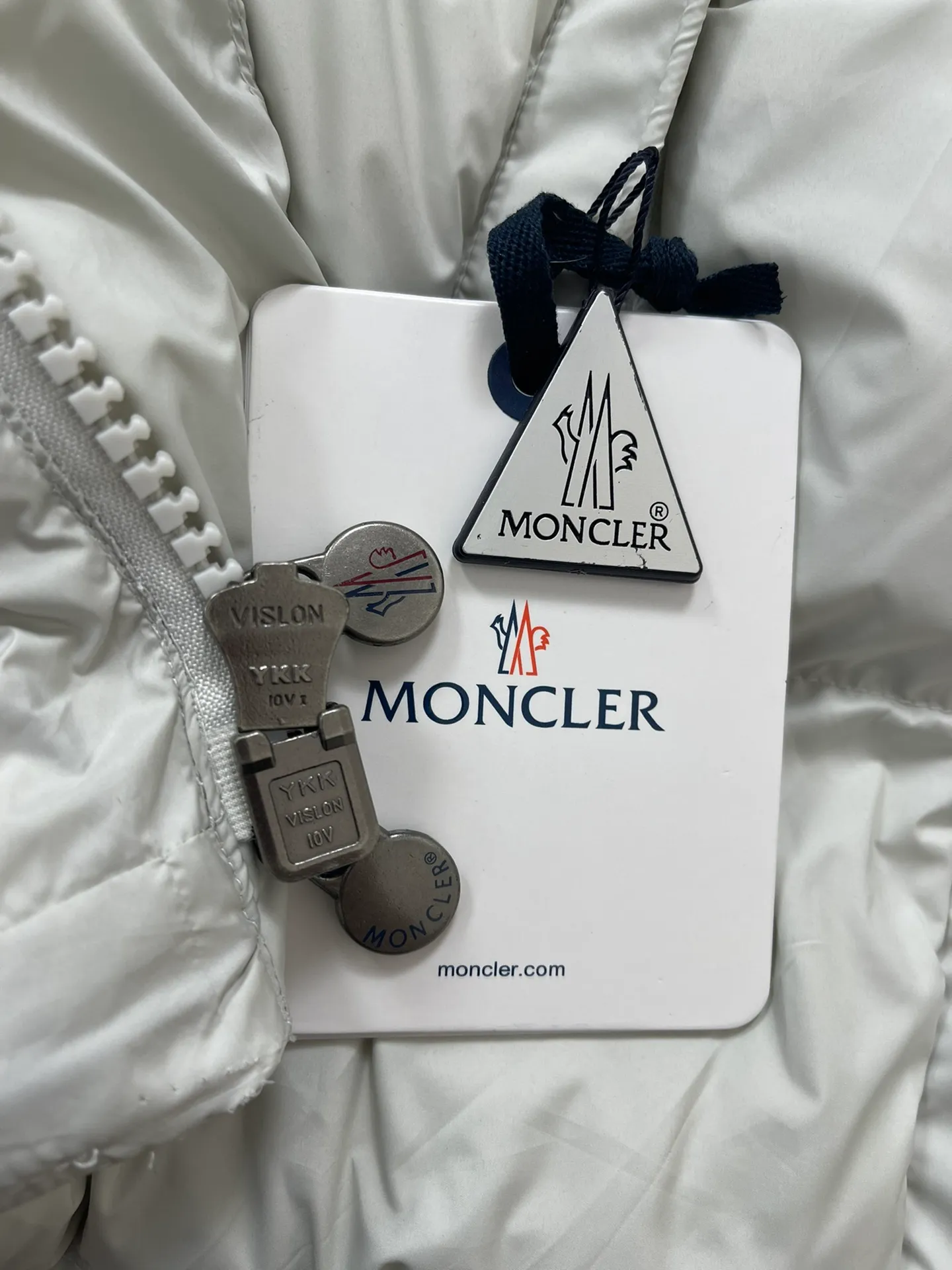 P1320 Moncler Maya 70 winter limited edition matte gray and white down jacket jacket Moncler Maya short down jacket is presented in a new color. Made from matte fabric and featuring signature checkered quilting, it reflects the essence of the Moncler brand. The style features a sharp silhouette with a detachable hood and adjustable hem in a timeless design suitable for every season and trend. The sleeves are embellished with classic patch pockets, and the down jacket is suitable for both men and women.  Fabric: 100% polyester fiber; Lining: 100% polyester fiber; Filling: 95 white duck down Craftsmanship: Made of polyester fiber fabric, polyester fiber lining, filled with down, detachable and adjustable hood, zipper closure, front windshield with snap buttons, zipper pockets, adjustable cuffs, elastic drawstring hem Size: 1 2 3 4 5 0555070