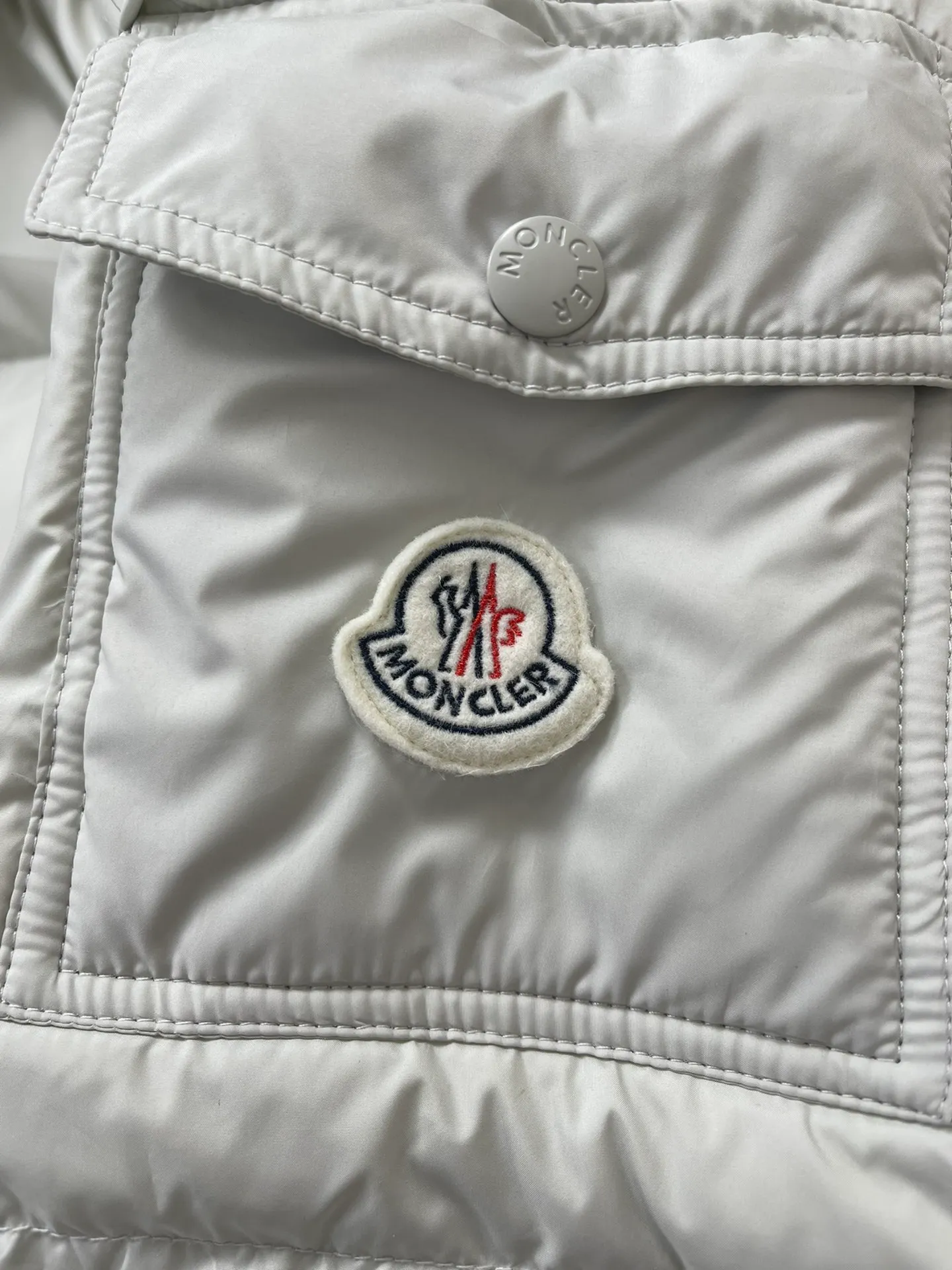 P1320 Moncler Maya 70 winter limited edition matte gray and white down jacket jacket Moncler Maya short down jacket is presented in a new color. Made from matte fabric and featuring signature checkered quilting, it reflects the essence of the Moncler brand. The style features a sharp silhouette with a detachable hood and adjustable hem in a timeless design suitable for every season and trend. The sleeves are embellished with classic patch pockets, and the down jacket is suitable for both men and women.  Fabric: 100% polyester fiber; Lining: 100% polyester fiber; Filling: 95 white duck down Craftsmanship: Made of polyester fiber fabric, polyester fiber lining, filled with down, detachable and adjustable hood, zipper closure, front windshield with snap buttons, zipper pockets, adjustable cuffs, elastic drawstring hem Size: 1 2 3 4 5 0555070