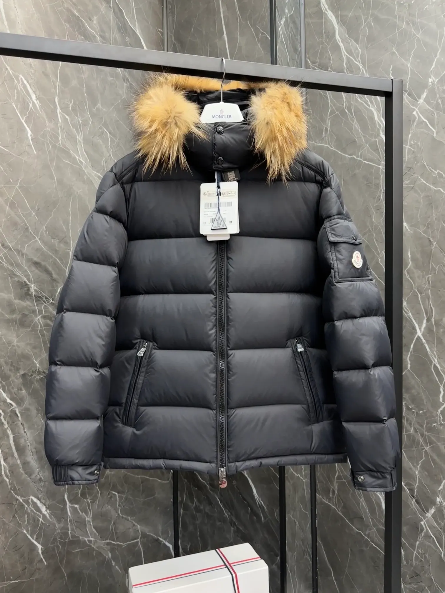 P1040 ⬆️Moncler Mayaf short men's down jacket. The hood is removable. The fur collar is removable. Based on Maya, a removable fur collar is added. The Mayaf men's hooded down jacket is made of functional nylon fabric, and the hood is equipped with removable synthetic material trim.  The Mayaf short down jacket is a reinterpretation of the classic Moncler Maya style in an instantly recognizable silhouette, with a removable hood and adjustable hem. Made from functional fabric with removable synthetic trim on the hood. The sleeves are embellished with classic patch pockets, reflecting the brand's signature style. Details •Made from functional fabric •Technical fabric lining •Down-filled •Push-stud collar •Detachable hood with removable synthetic trim •Zip closure •Zip pockets •Patch pockets with press-stud •Adjustable elastic cuffs •Adjustable drawstring hem
