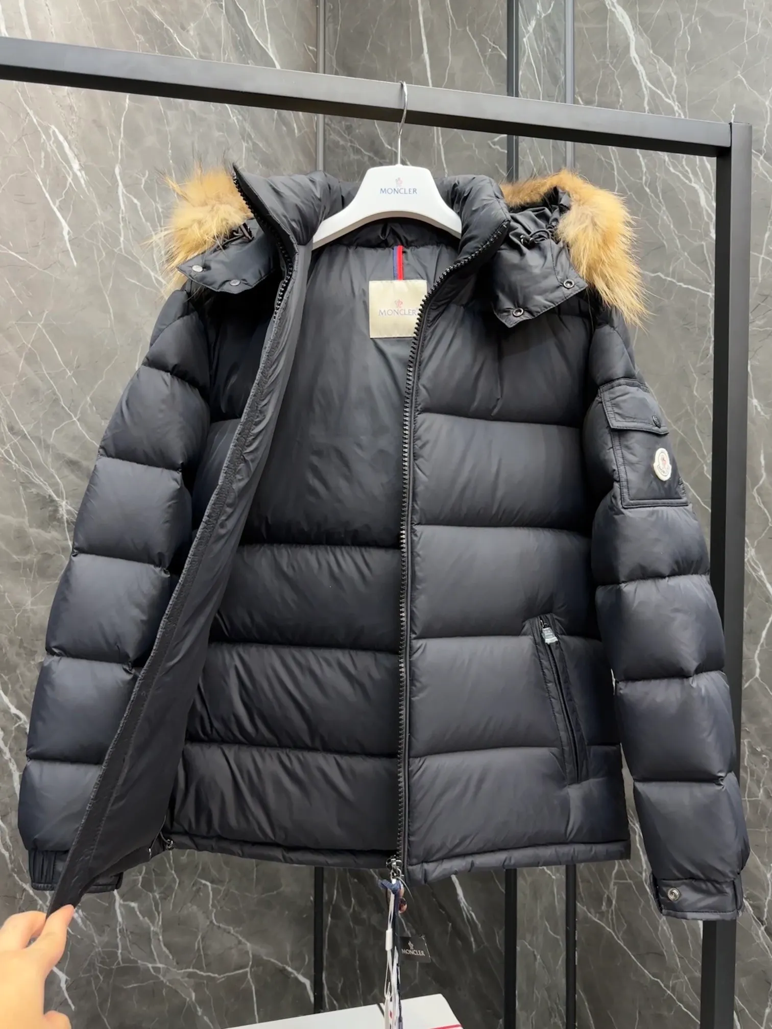 P1040 ⬆️Moncler Mayaf short men's down jacket. The hood is removable. The fur collar is removable. Based on Maya, a removable fur collar is added. The Mayaf men's hooded down jacket is made of functional nylon fabric, and the hood is equipped with removable synthetic material trim.  The Mayaf short down jacket is a reinterpretation of the classic Moncler Maya style in an instantly recognizable silhouette, with a removable hood and adjustable hem. Made from functional fabric with removable synthetic trim on the hood. The sleeves are embellished with classic patch pockets, reflecting the brand's signature style. Details •Made from functional fabric •Technical fabric lining •Down-filled •Push-stud collar •Detachable hood with removable synthetic trim •Zip closure •Zip pockets •Patch pockets with press-stud •Adjustable elastic cuffs •Adjustable drawstring hem