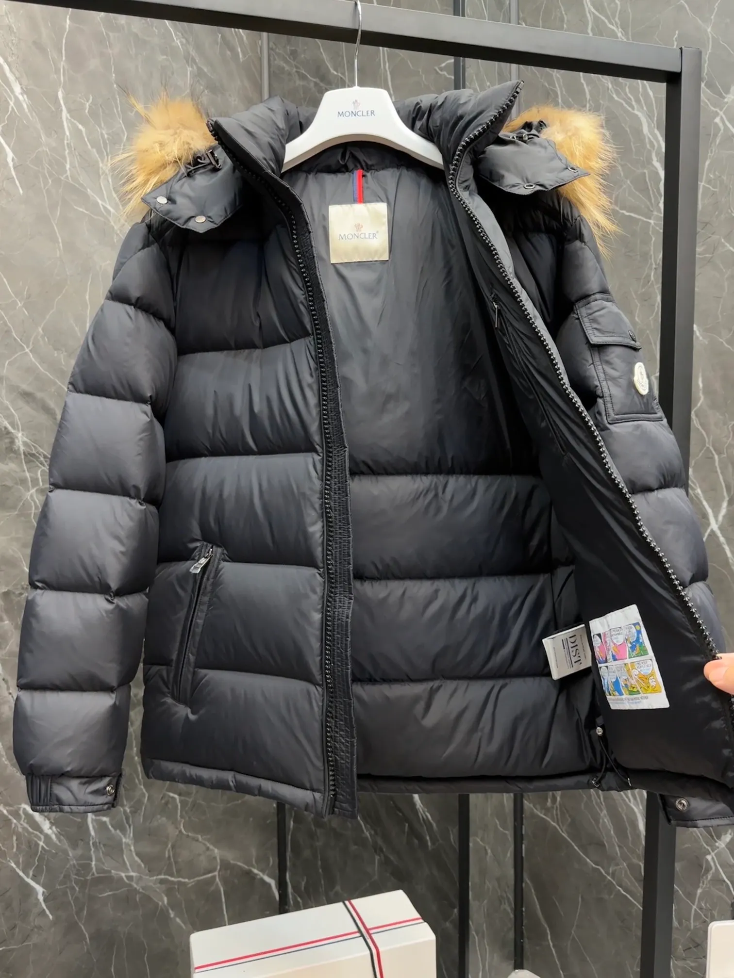 P1040 ⬆️Moncler Mayaf short men's down jacket. The hood is removable. The fur collar is removable. Based on Maya, a removable fur collar is added. The Mayaf men's hooded down jacket is made of functional nylon fabric, and the hood is equipped with removable synthetic material trim.  The Mayaf short down jacket is a reinterpretation of the classic Moncler Maya style in an instantly recognizable silhouette, with a removable hood and adjustable hem. Made from functional fabric with removable synthetic trim on the hood. The sleeves are embellished with classic patch pockets, reflecting the brand's signature style. Details •Made from functional fabric •Technical fabric lining •Down-filled •Push-stud collar •Detachable hood with removable synthetic trim •Zip closure •Zip pockets •Patch pockets with press-stud •Adjustable elastic cuffs •Adjustable drawstring hem