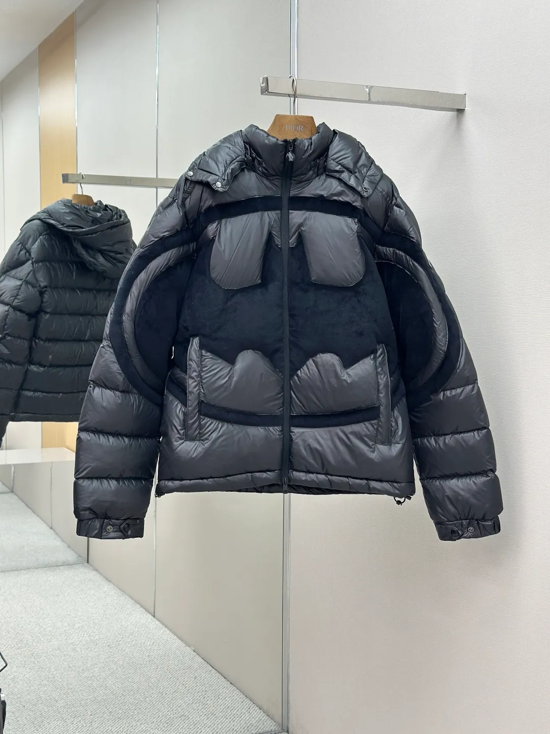 P1210 Moncler Batman Logo Down Jacket Customized black premium carbon black coated windbreaker fabric Customized Korean trendy velvet knitted fabric Made of 400D calendered bile fabric National standard 95 white goose down (welcome to test) Full of down content Warmth and light fluffy Craftsmanship to create a joint series Decorated with the Batman logo on the front Inspired by the famous superhero High degree of recognition The iconic Moncler embroidered logo is present on the sleeves It highlights the brand style and pays tribute to the classics. It is also an interpretation of modern fashion. It tightly locks in body temperature and enjoys warmth and comfort. It becomes the most intimate companion in winter. Process 1: Computer laser burning and cutting. It uses a high-energy laser beam to instantly melt the fabric fibers at high temperature. Precise cutting and engraving on the fabric according to the original pattern. The edges are flat to achieve seamless splicing. It effectively prevents the penetration of cold wind and improves the thermal insulation performance of the down jacket. Process 2: Computer mechanical down filling. Priority is given to making the inner liner pattern to determine the down filling area according to the original three-dimensional effect to determine the gram weight of down per square meter, thereby calculating the filling amount of each cut piece. The computer down filling machine uses a digital weighing unit to achieve stable measurement. Process 3: Computer template machine line running process. The line running process of the computer template machine shows extremely high neatness and smoothness. The craftsman accurately controls the size during the operation to ensure that each row line meets the design requirements. The lines of the entire template are smooth and unified, clean and beautiful. Paving: Customized 1:1 Moncler snap button Customized 1:1 Moncler zipper Customized 1:1 Moncler adjustment buckle Customized 1:1 Moncler pendant Customized 1:1 Moncler machine eye Customized 1:1 Moncler embroidered logo Customized 1:1 Moncler trademark Function: Detachable and adjustable hood. Match as you like Size: 1-6