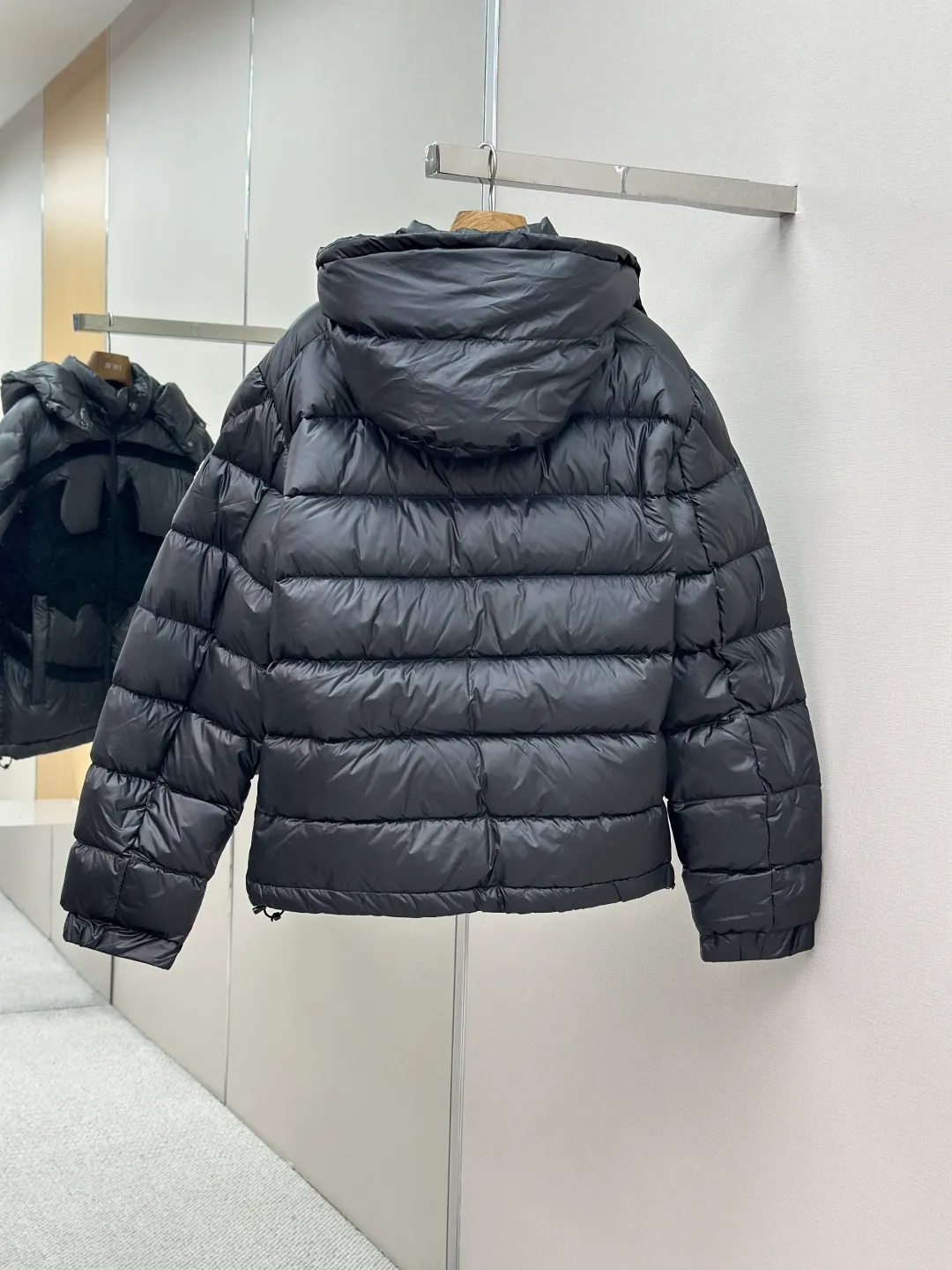 P1210 Moncler Batman Logo Down Jacket Customized black premium carbon black coated windbreaker fabric Customized Korean trendy velvet knitted fabric Made of 400D calendered bile fabric National standard 95 white goose down (welcome to test) Full of down content Warmth and light fluffy Craftsmanship to create a joint series Decorated with the Batman logo on the front Inspired by the famous superhero High degree of recognition The iconic Moncler embroidered logo is present on the sleeves It highlights the brand style and pays tribute to the classics. It is also an interpretation of modern fashion. It tightly locks in body temperature and enjoys warmth and comfort. It becomes the most intimate companion in winter. Process 1: Computer laser burning and cutting. It uses a high-energy laser beam to instantly melt the fabric fibers at high temperature. Precise cutting and engraving on the fabric according to the original pattern. The edges are flat to achieve seamless splicing. It effectively prevents the penetration of cold wind and improves the thermal insulation performance of the down jacket. Process 2: Computer mechanical down filling. Priority is given to making the inner liner pattern to determine the down filling area according to the original three-dimensional effect to determine the gram weight of down per square meter, thereby calculating the filling amount of each cut piece. The computer down filling machine uses a digital weighing unit to achieve stable measurement. Process 3: Computer template machine line running process. The line running process of the computer template machine shows extremely high neatness and smoothness. The craftsman accurately controls the size during the operation to ensure that each row line meets the design requirements. The lines of the entire template are smooth and unified, clean and beautiful. Paving: Customized 1:1 Moncler snap button Customized 1:1 Moncler zipper Customized 1:1 Moncler adjustment buckle Customized 1:1 Moncler pendant Customized 1:1 Moncler machine eye Customized 1:1 Moncler embroidered logo Customized 1:1 Moncler trademark Function: Detachable and adjustable hood. Match as you like Size: 1-6